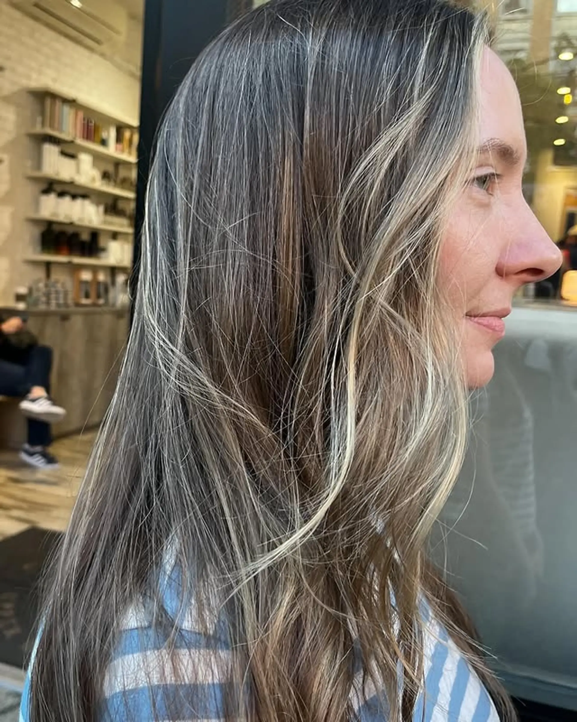 Long, layered hairstyle with face-framing ash blonde highlights. 1