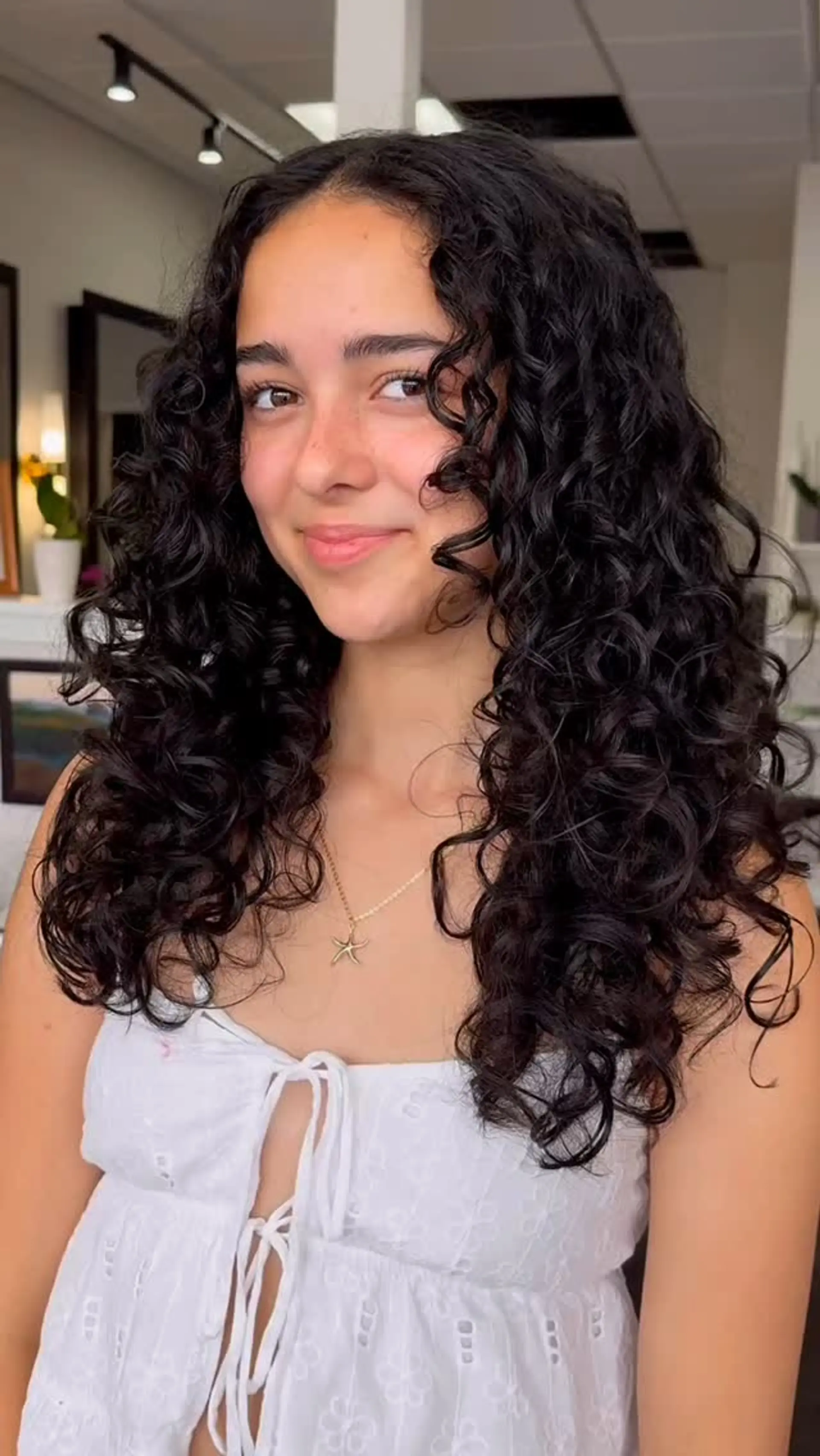Long, voluminous dark curly hair with defined, bouncy ringlets and face-framing layers. 1