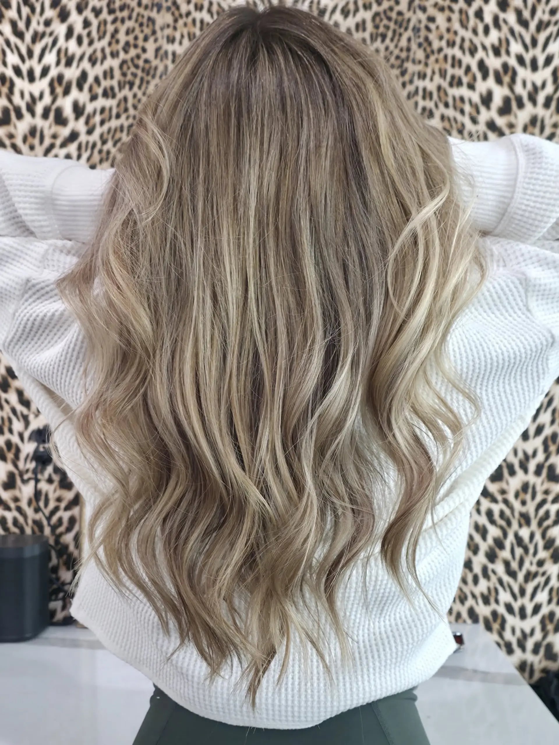 Long hair styled in soft, undone waves featuring a blended cool ash blonde balayage with a shadowed root. 1