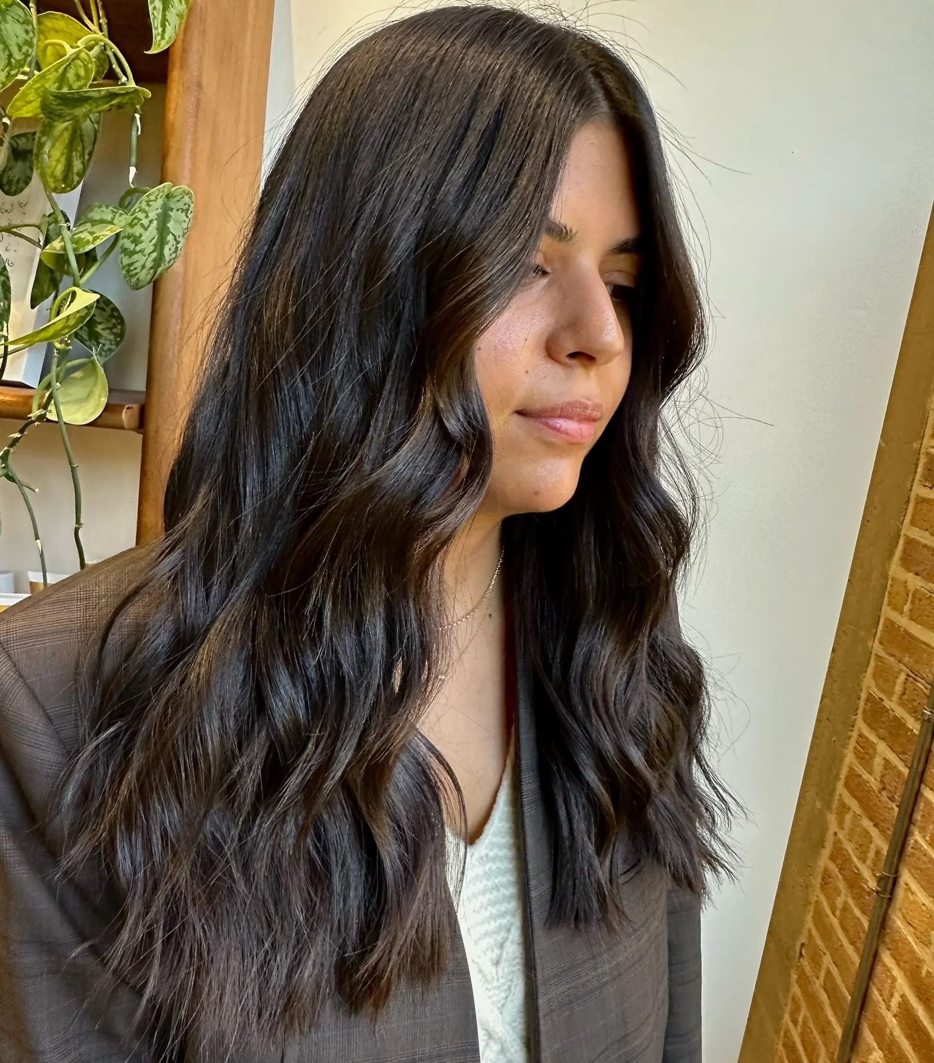 Long brunette hair with soft waves and subtle layering. 1