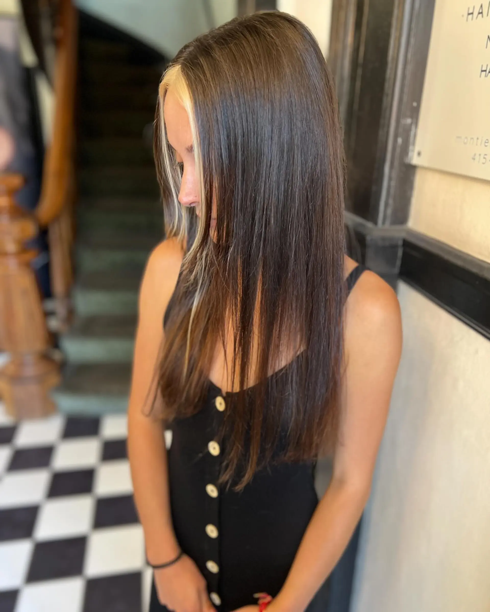 Straight, glossy dark brown hair falling past the chest, featuring a bold blonde face-framing money piece highlight. 1