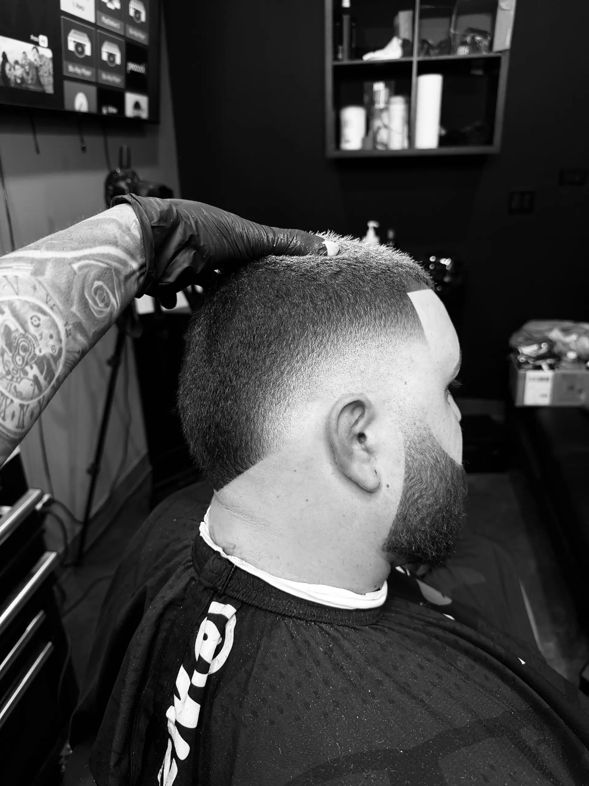 A sharp, short buzz cut paired with a seamless temple fade and a clean beard line-up. 1