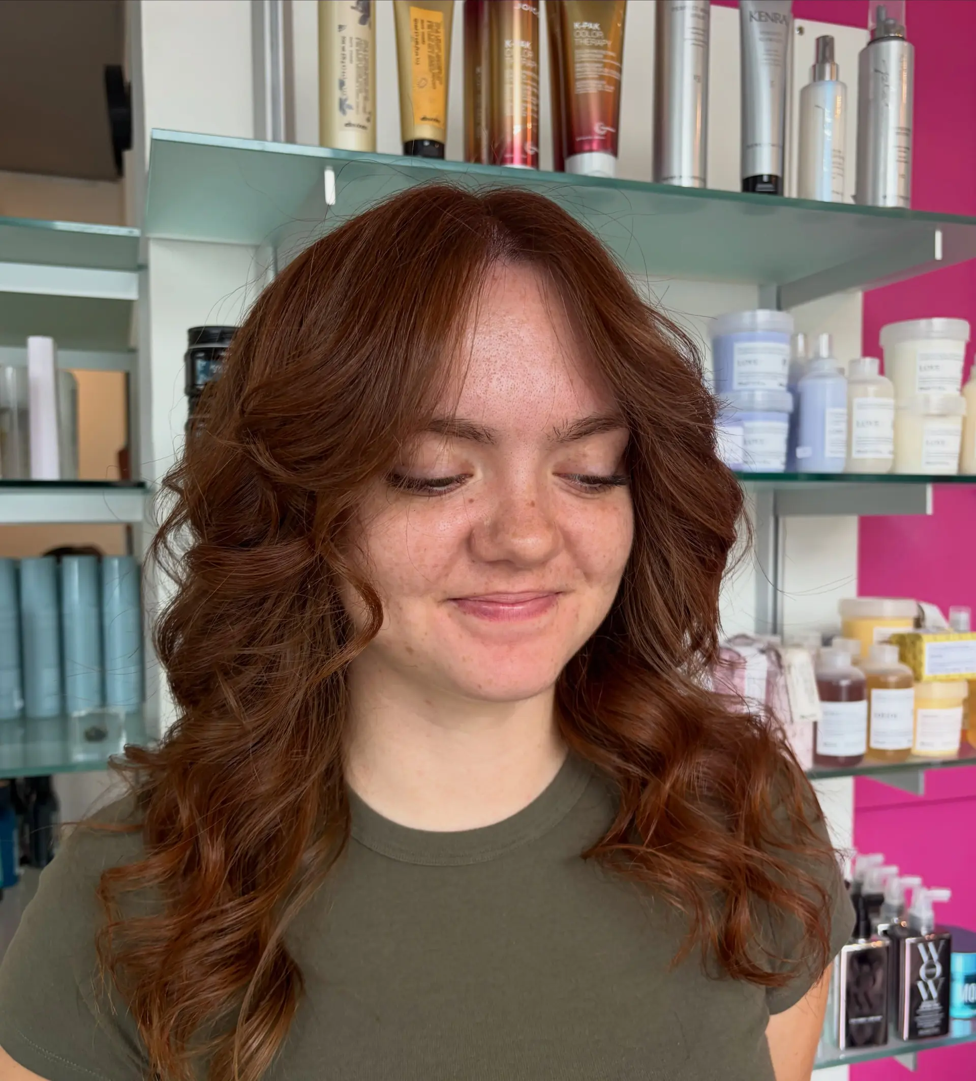 Medium-length auburn hair featuring soft face-framing curtain bangs and bouncy, voluminous layers styled into gentle outward waves. 1