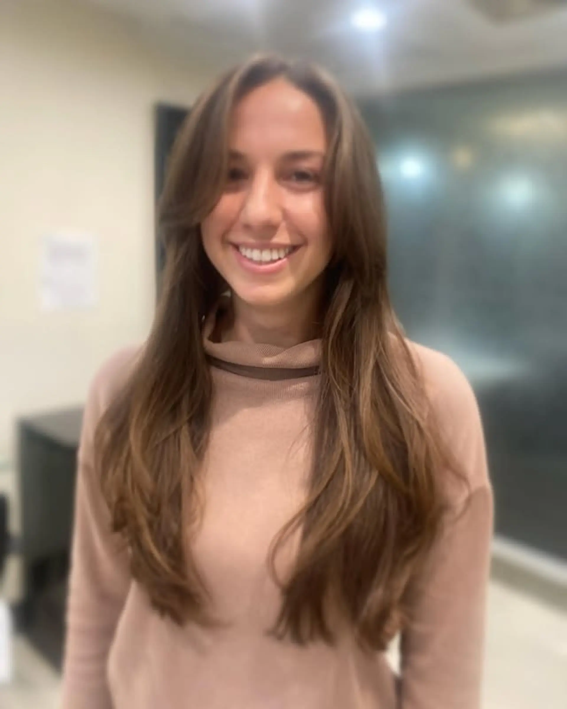 Long layered haircut with face-framing layers and curtain bangs. 1