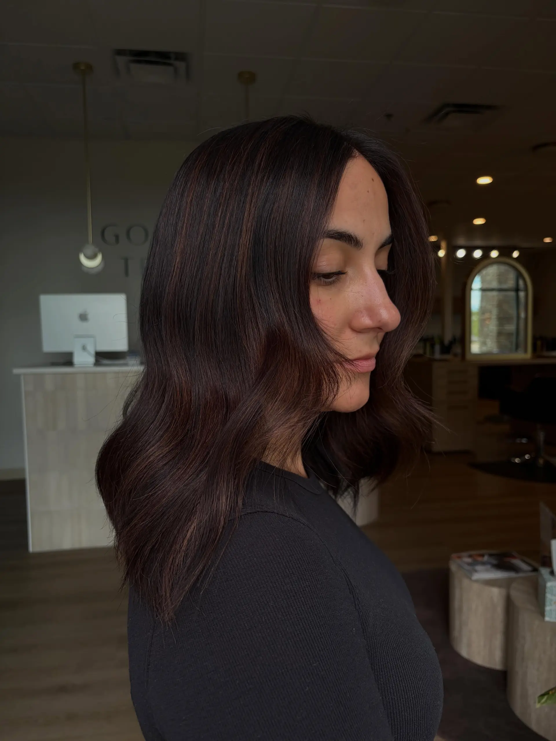 Medium-length glossy brunette hair styled into soft, elegant waves with face-framing layers. 1