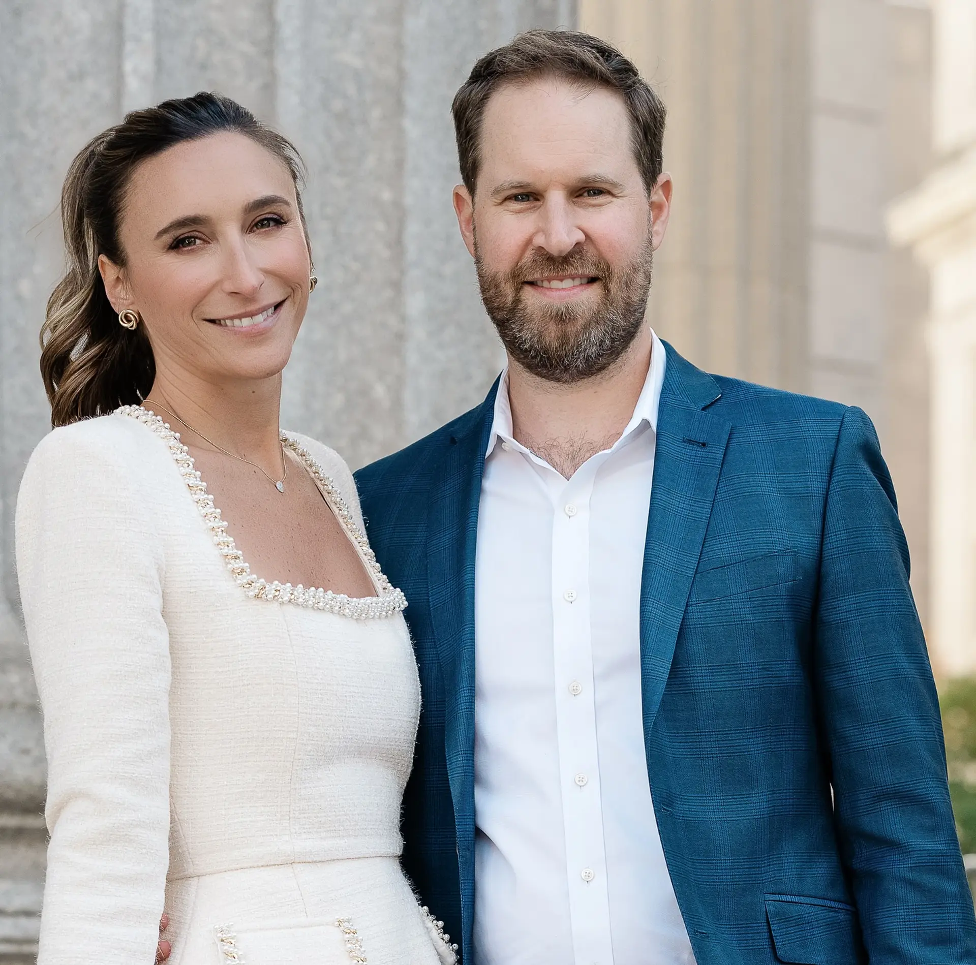 A sleek, polished bridal hairstyle pulled back into a ponytail with soft, textured waves. 1