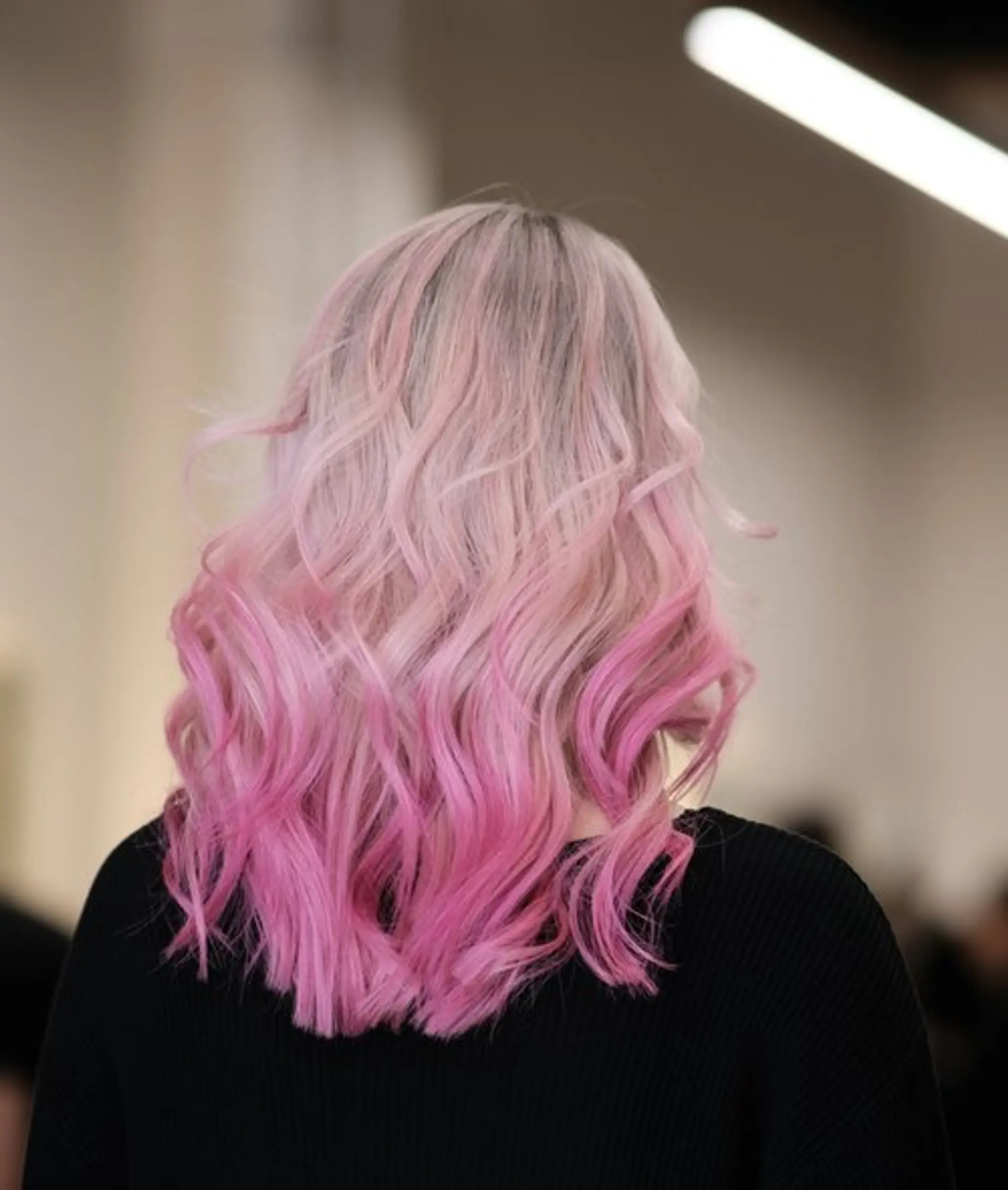 A medium length wavy hairstyle with a striking ombre effect from light pastel pink to hot pink. 1