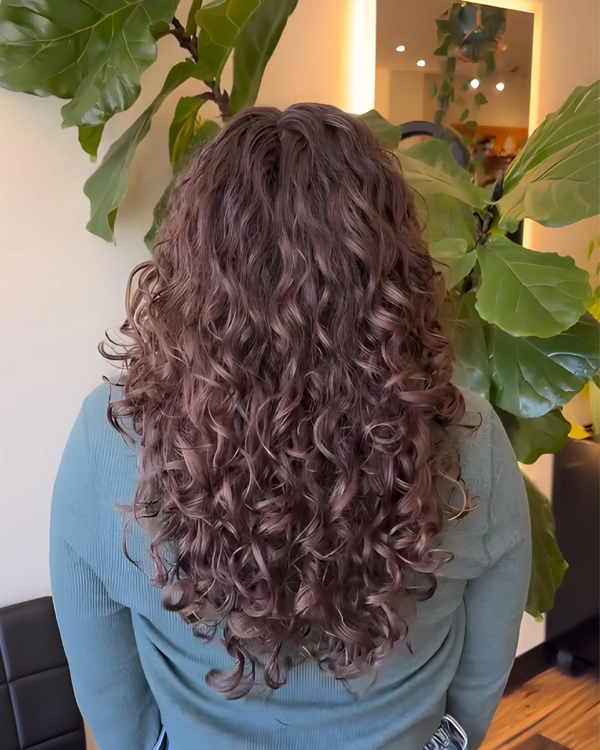 Long, naturally curly hair cut with customized shaping and layering to create bouncy, defined curls with balanced volume. 1