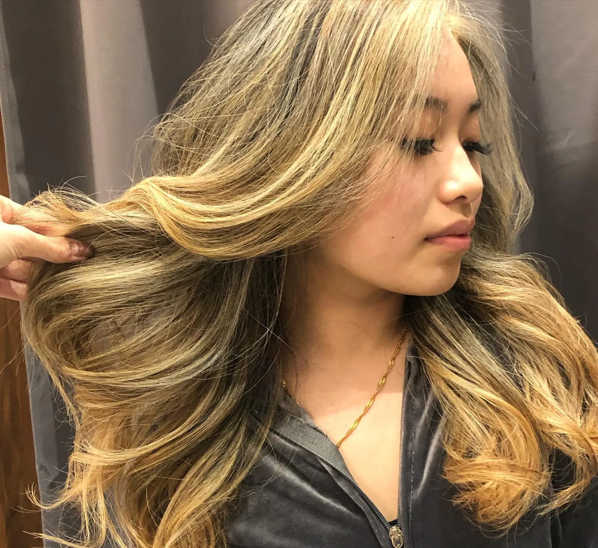 Long layered hair featuring seamless warm golden blonde balayage highlights styled into loose, flowing waves. 1