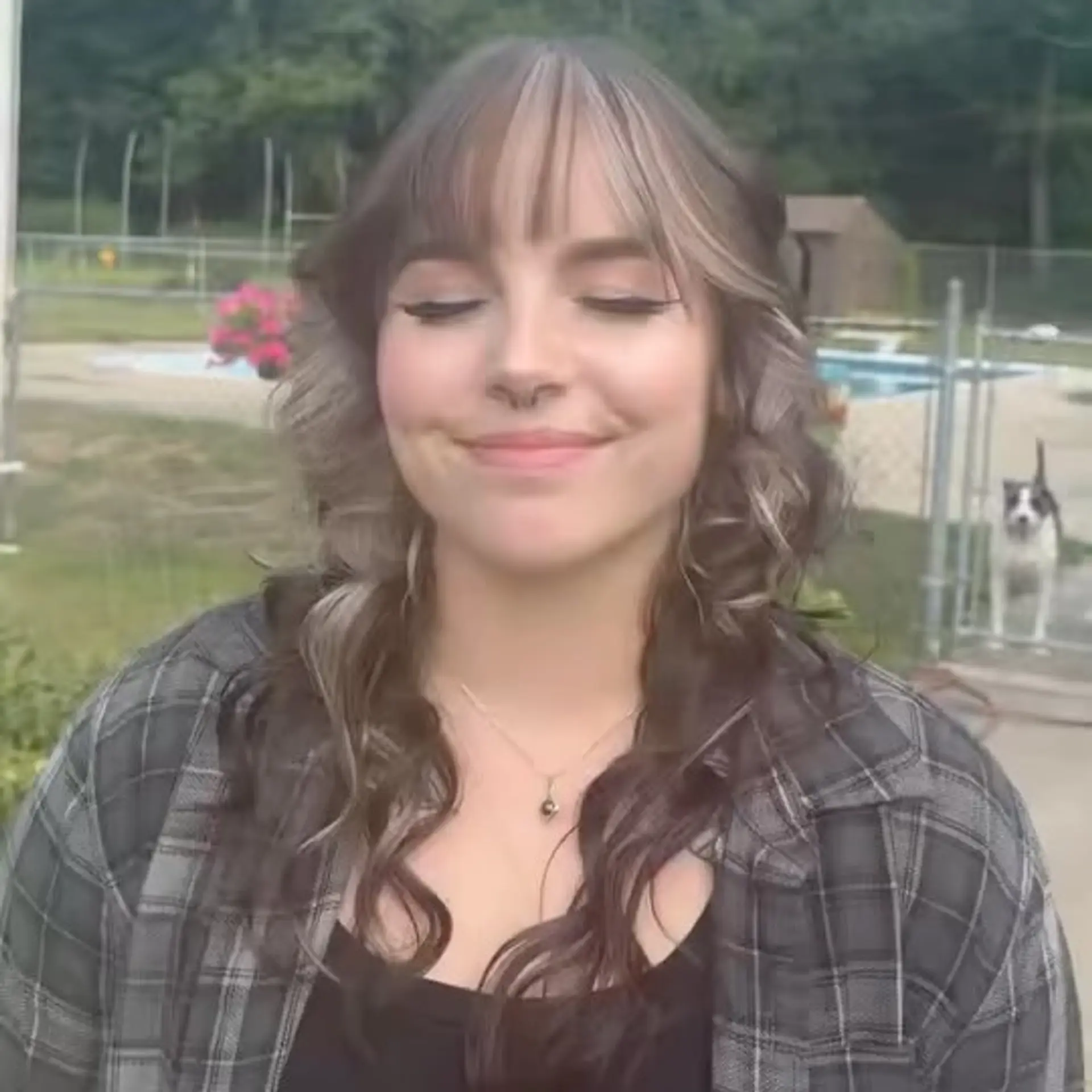 A mid-length layered wolf cut styled with loose waves, face-framing layers, and delicate wispy fringe bangs. 1