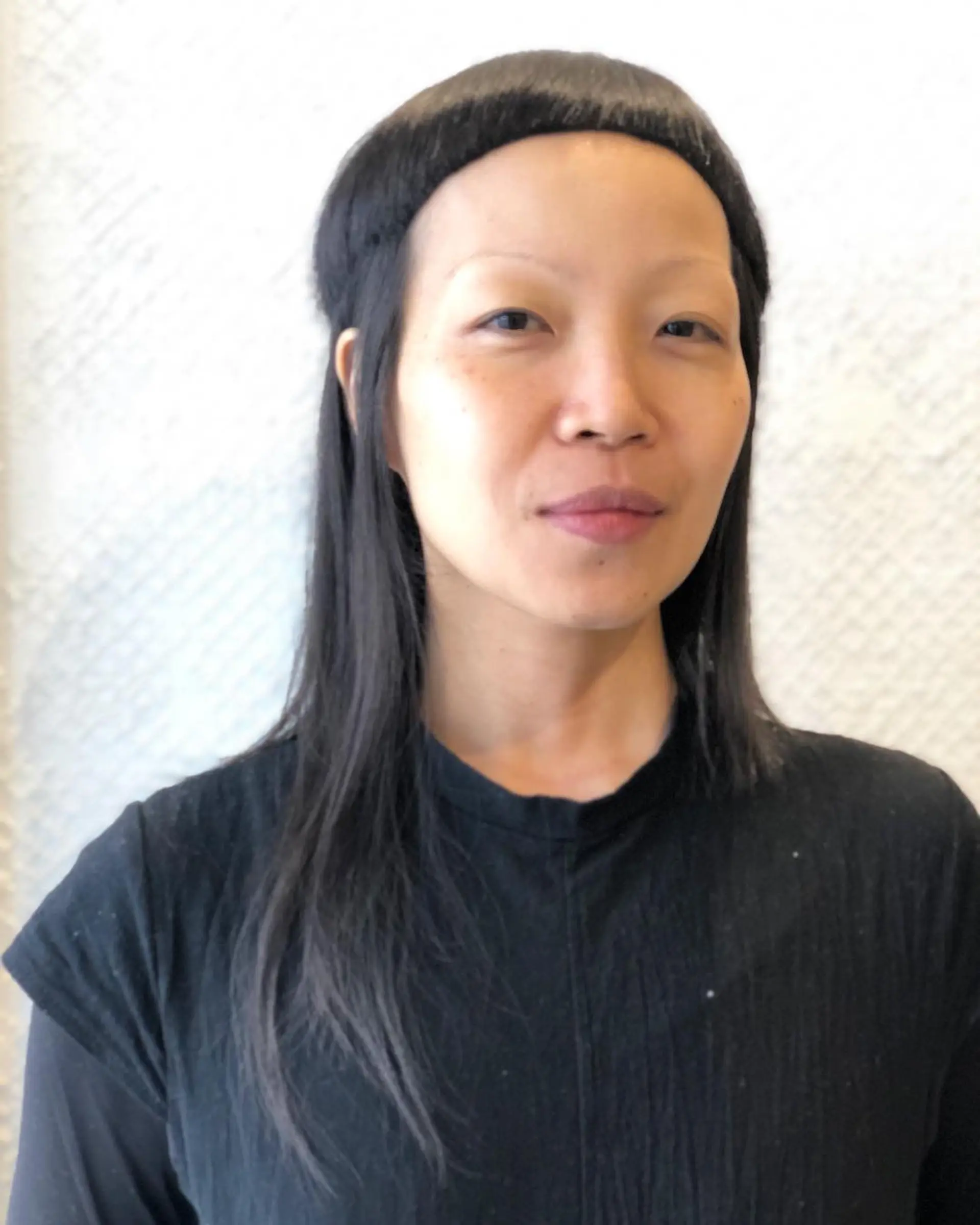 An edgy hairstyle with a blunt arc fringe combined with medium-length sleek black hair, emphasizing a minimalist and avant-garde look. 2