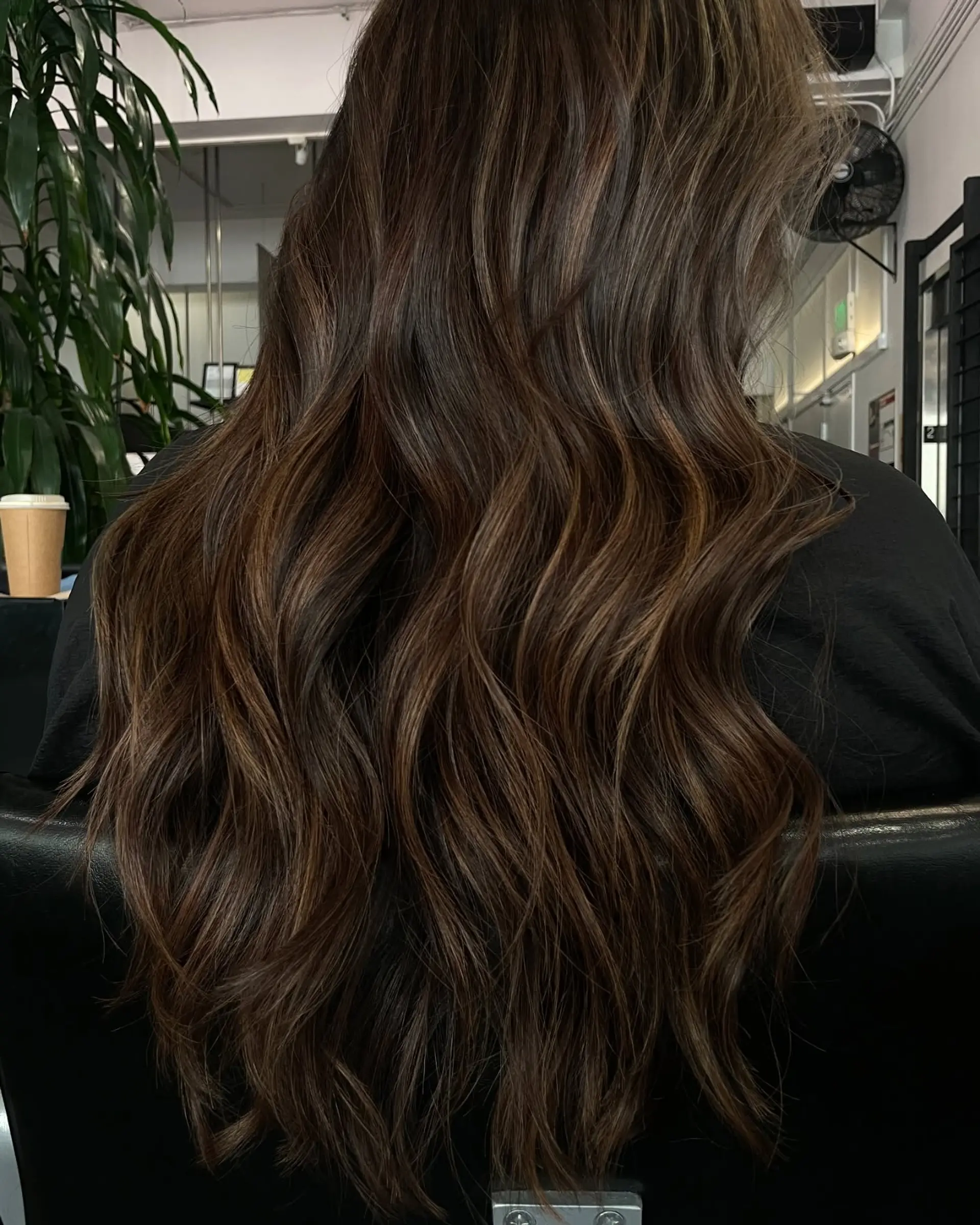 Long brunette hair styled in loose, dimensional waves with subtle warm highlights and lowlights. 1