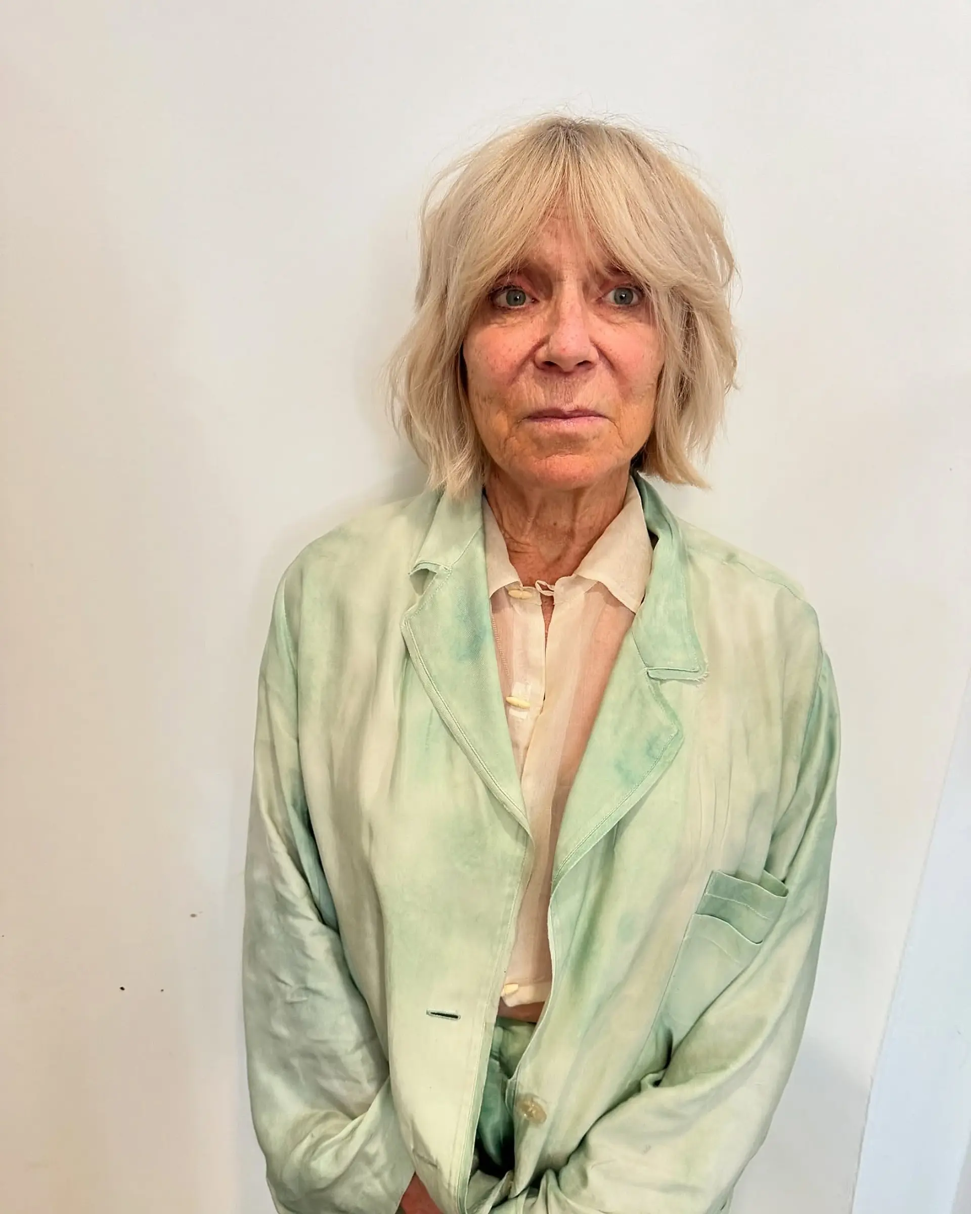 A textured chin-length shaggy bob with soft, piecey curtain bangs in a cool blonde shade. 1