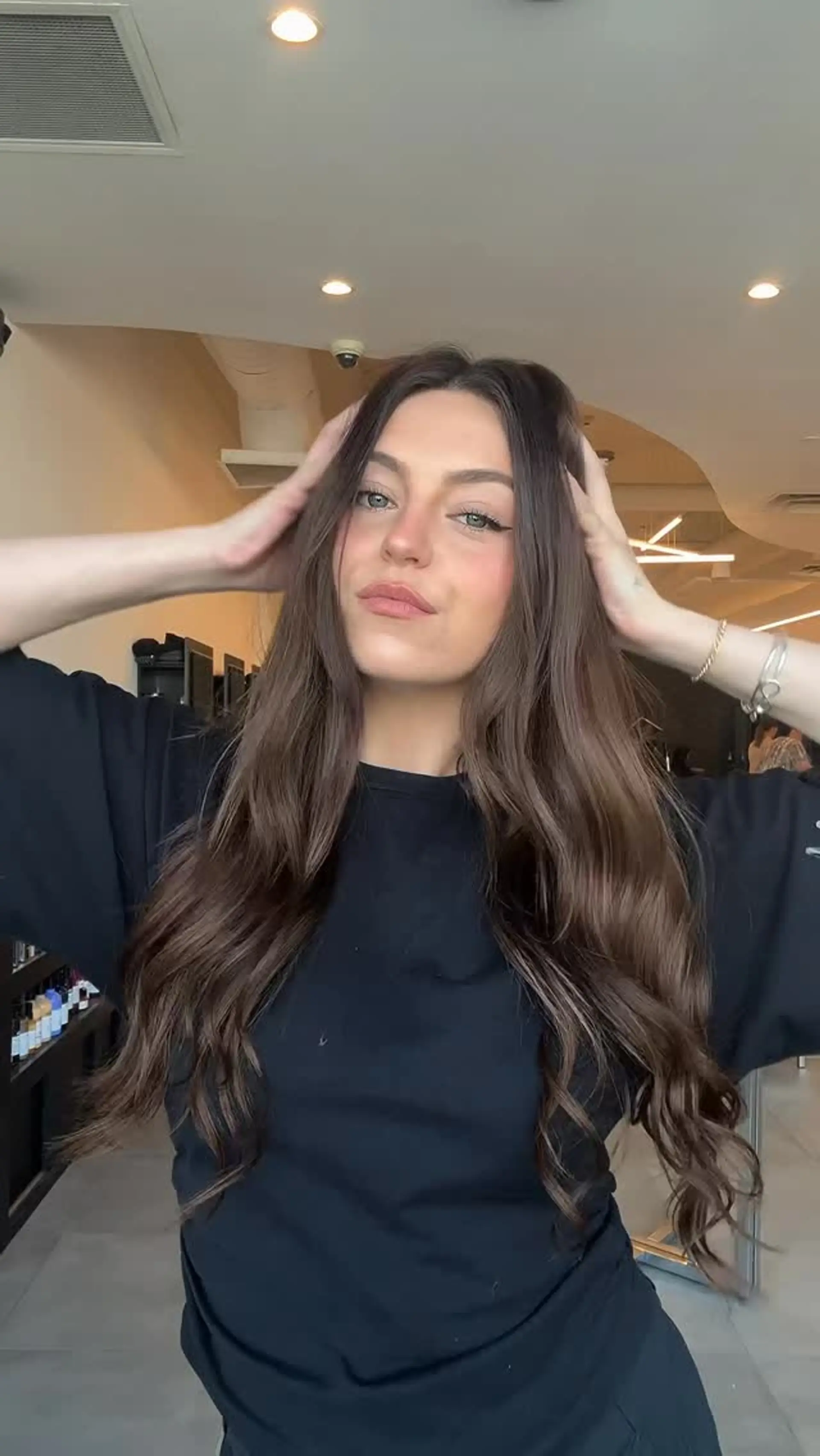 Long, rich brunette hair parted down the middle with smooth volume and soft waves through the lengths. 1