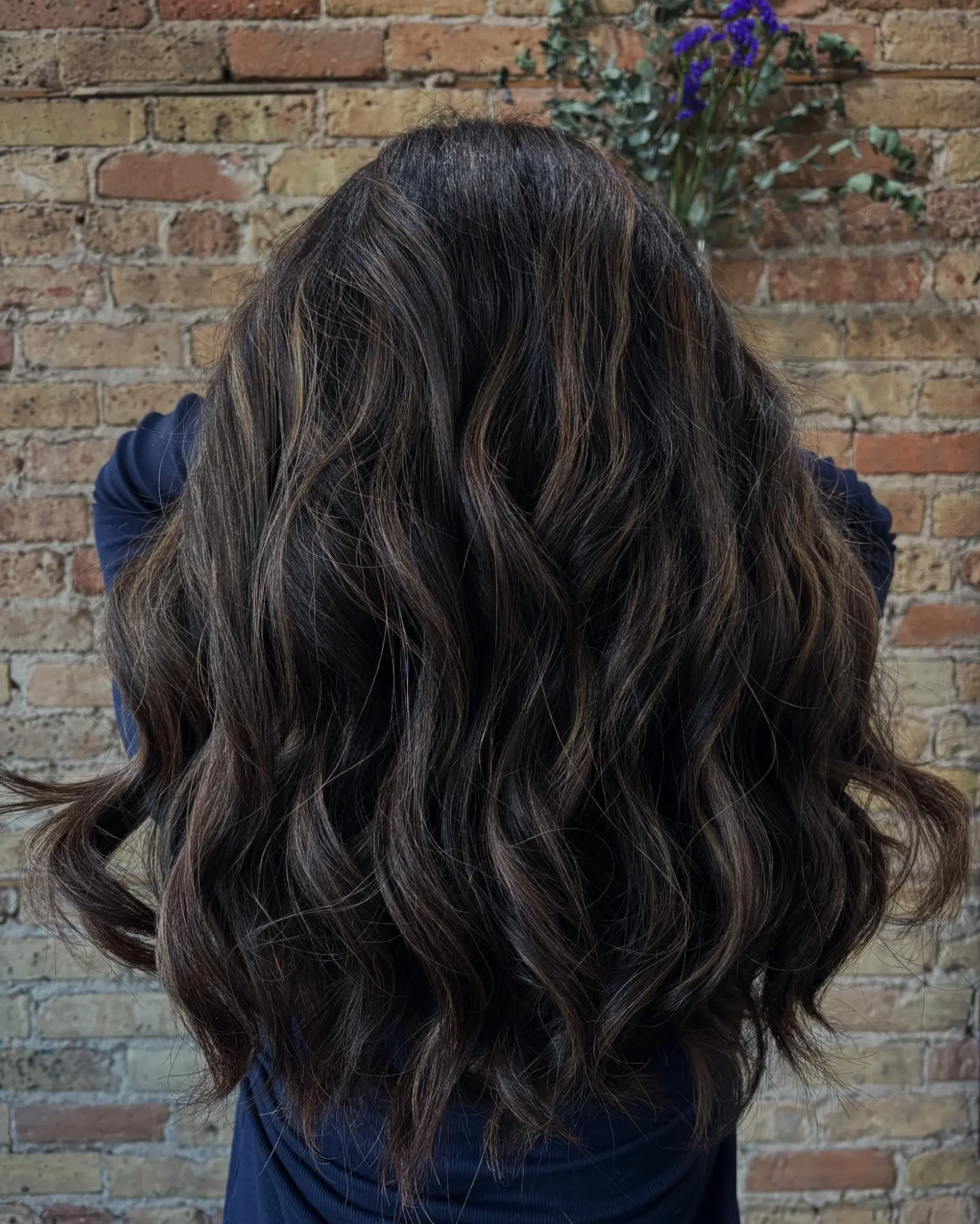 Long, dark brunette hair styled in loose waves with subtle dimensional balayage highlights. 1