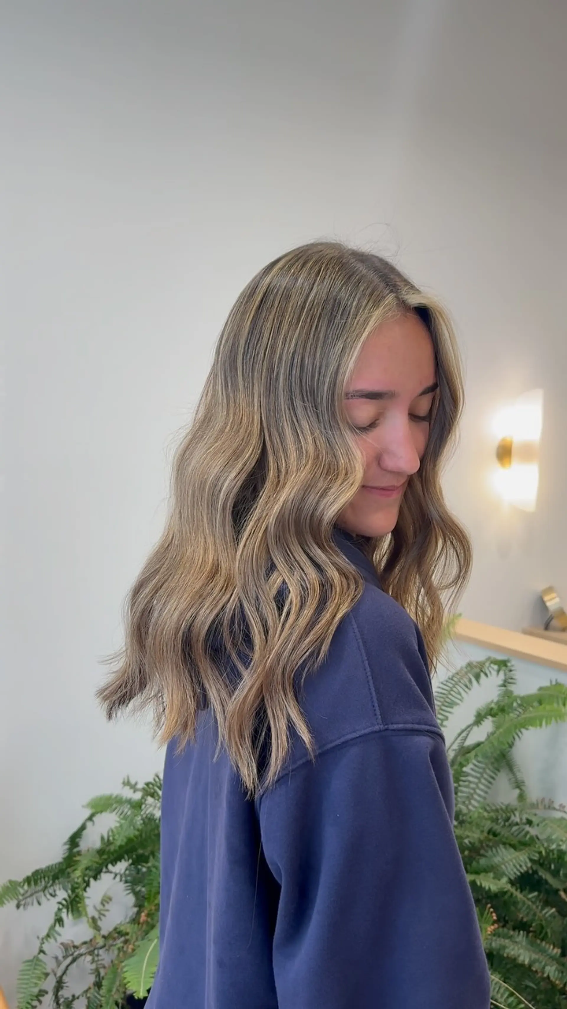 Medium-to-long dimensional bronde hair styled into soft, flowing waves with brighter face-framing pieces. 1