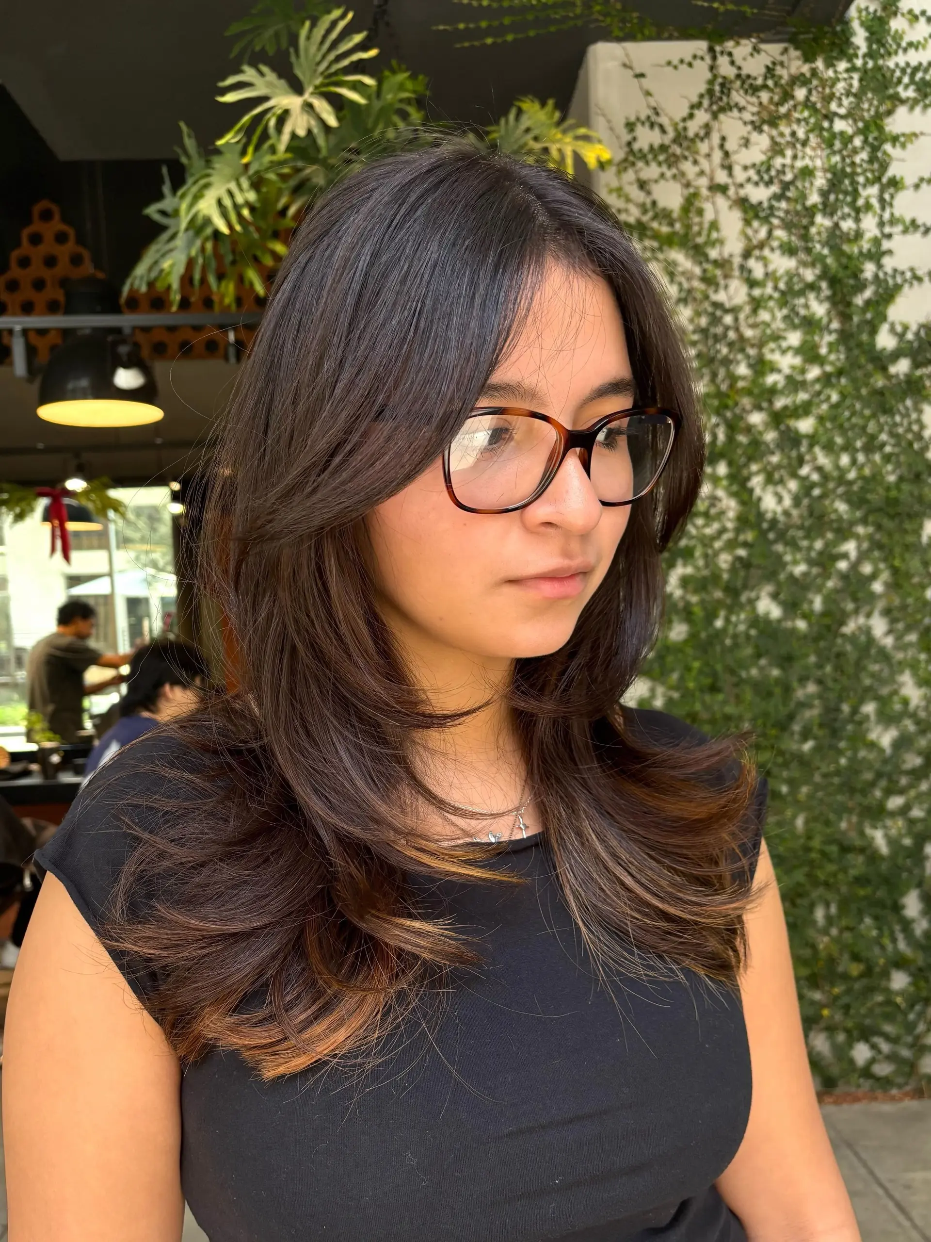 Long dark brown hair cut with soft face-framing curtain layers and ends flicked outward in a voluminous blowout. 1
