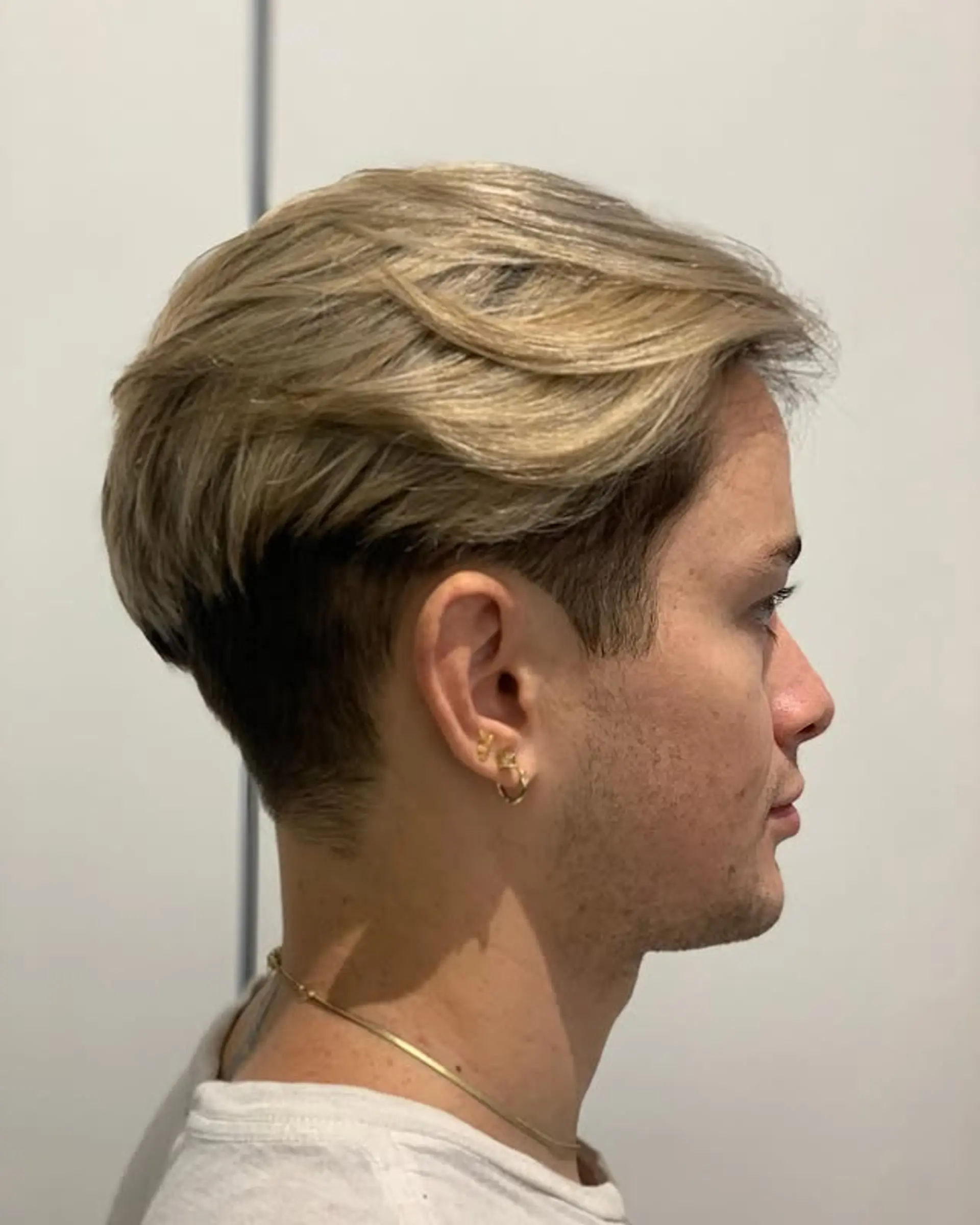 A short, textured crop with a modern undercut and layered top, highlighted for added dimension. 1
