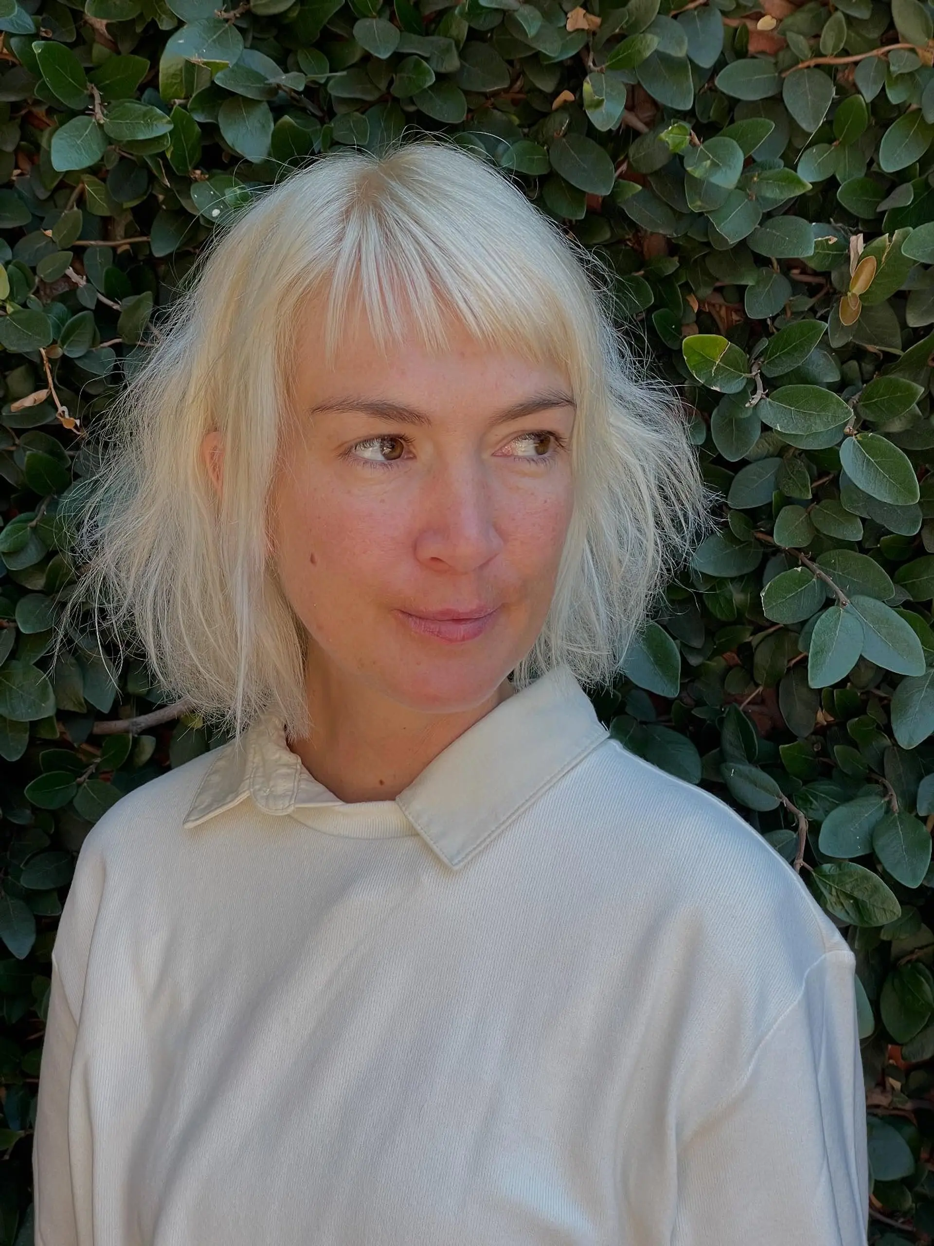 A textured chin-length platinum blonde bob featuring short, piecey micro bangs. 1
