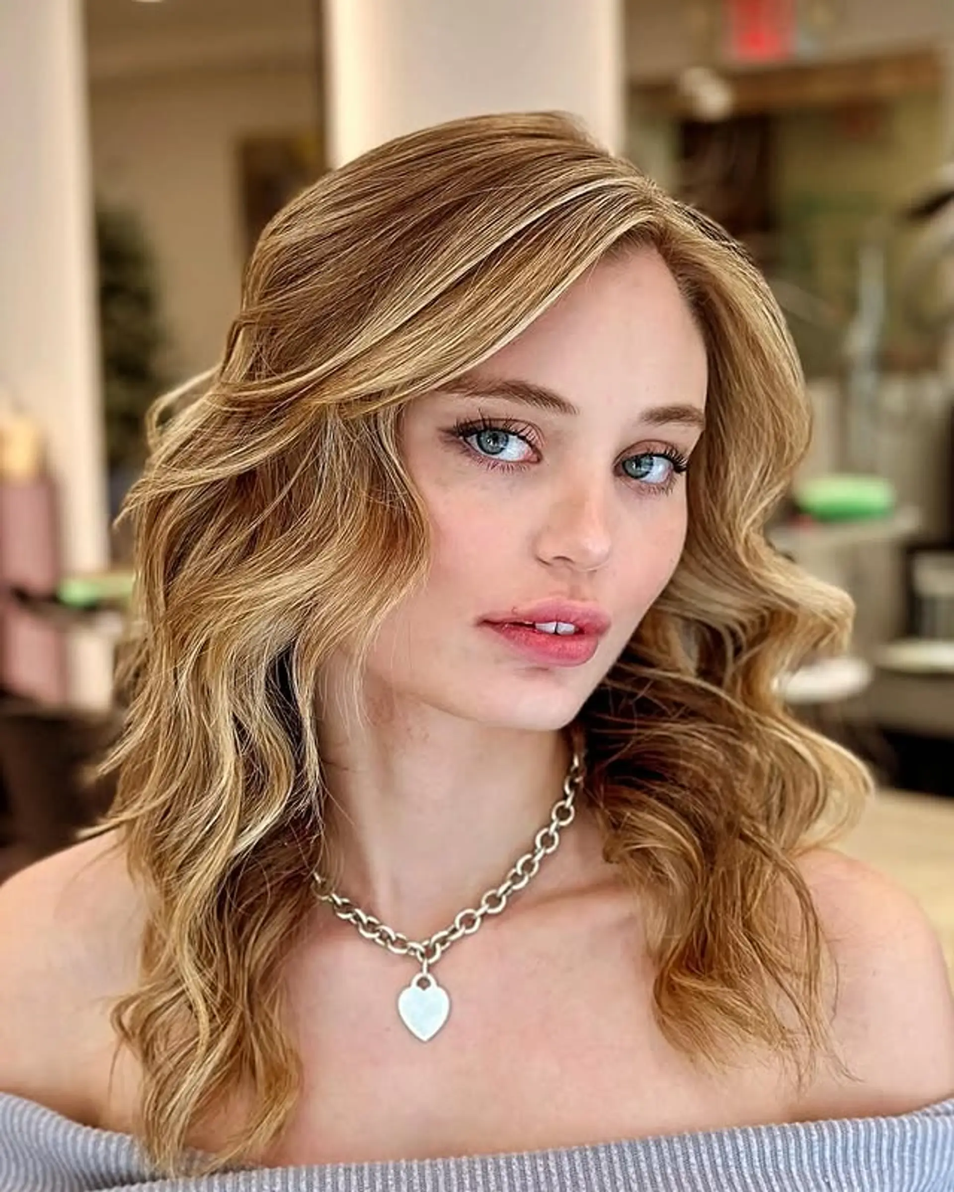 This hairstyle features medium-length wavy hair with loose, beachy waves. 1