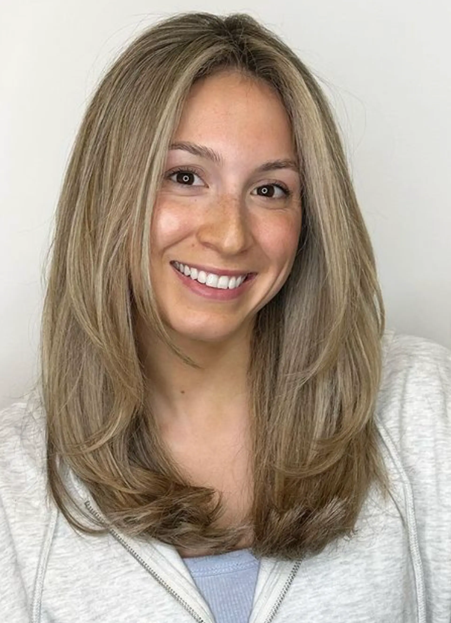 A sleek, straight, medium-length golden blonde hairstyle with light brown undertones and layered cuts, adding volume and movement.

Color by @simabeautynyc
Cut and style by @juliamannino_hair
 1