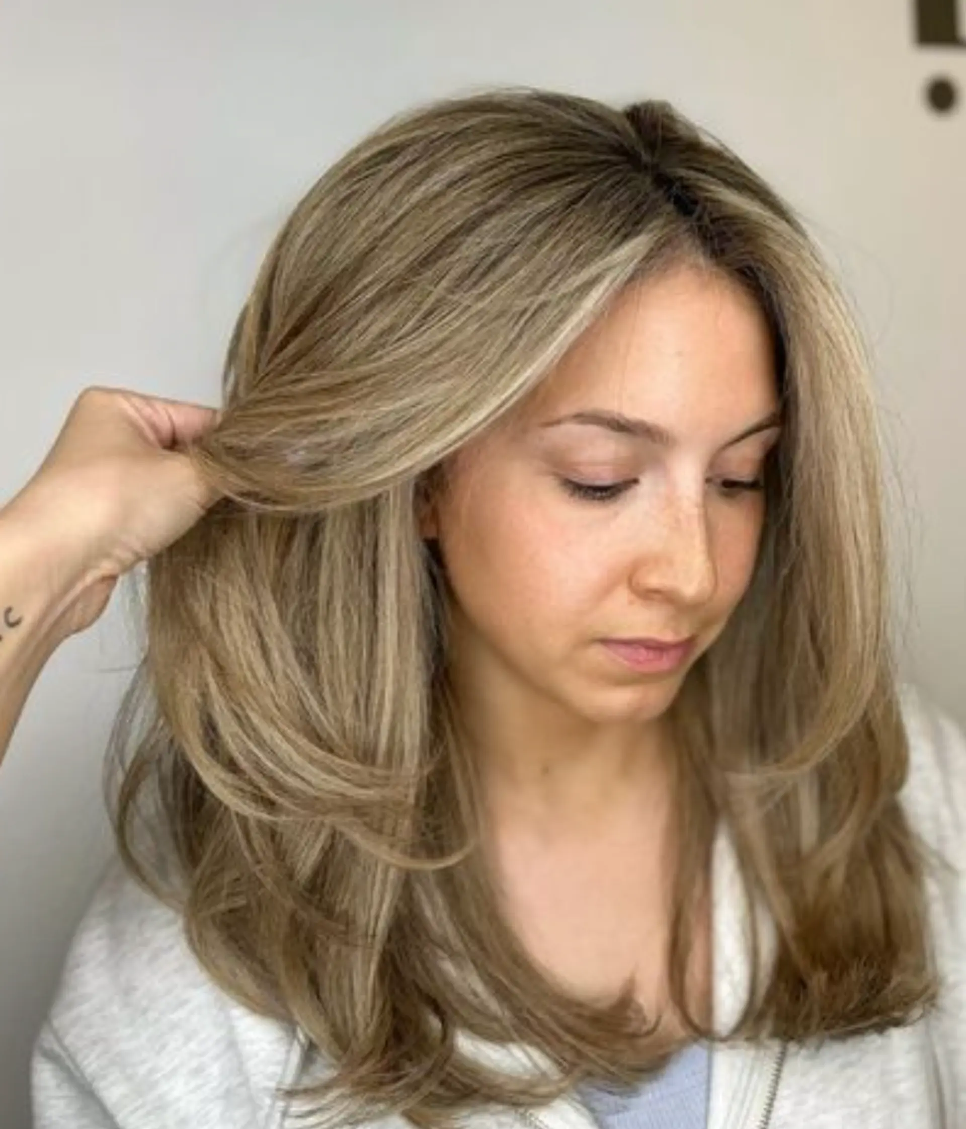 A sleek, straight, medium-length golden blonde hairstyle with light brown undertones and layered cuts, adding volume and movement.

Color by @simabeautynyc
Cut and style by @juliamannino_hair
 2