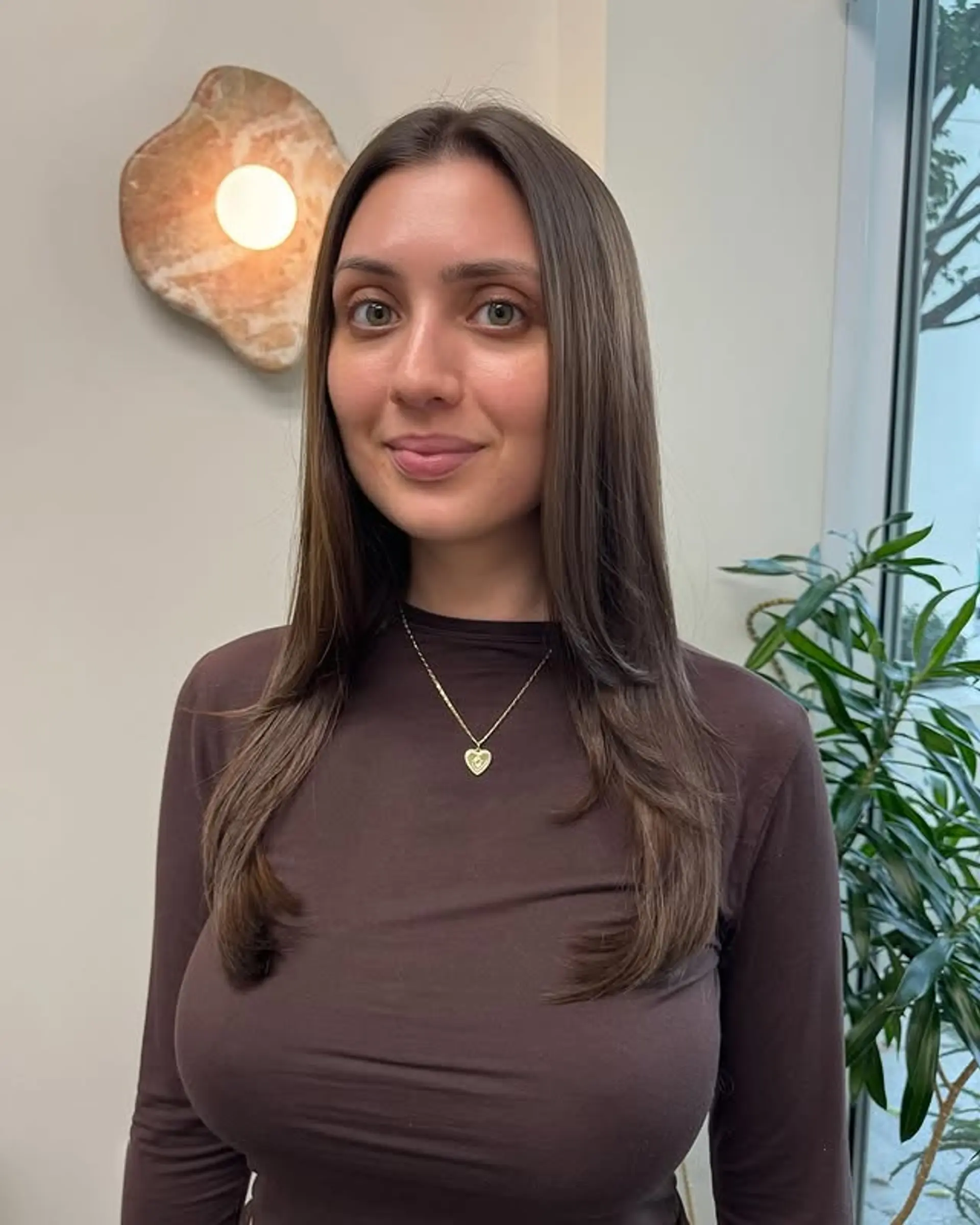 A long, straight hairstyle with layers that frame the face. 1