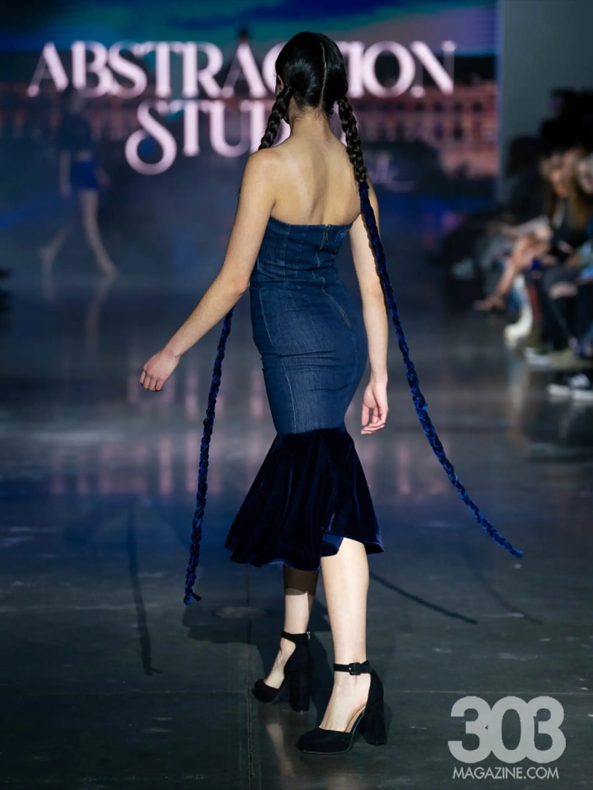 Sleek center-parted twin braids extended with dramatic, floor-length blue velvet ribbons for a runway presentation. 1