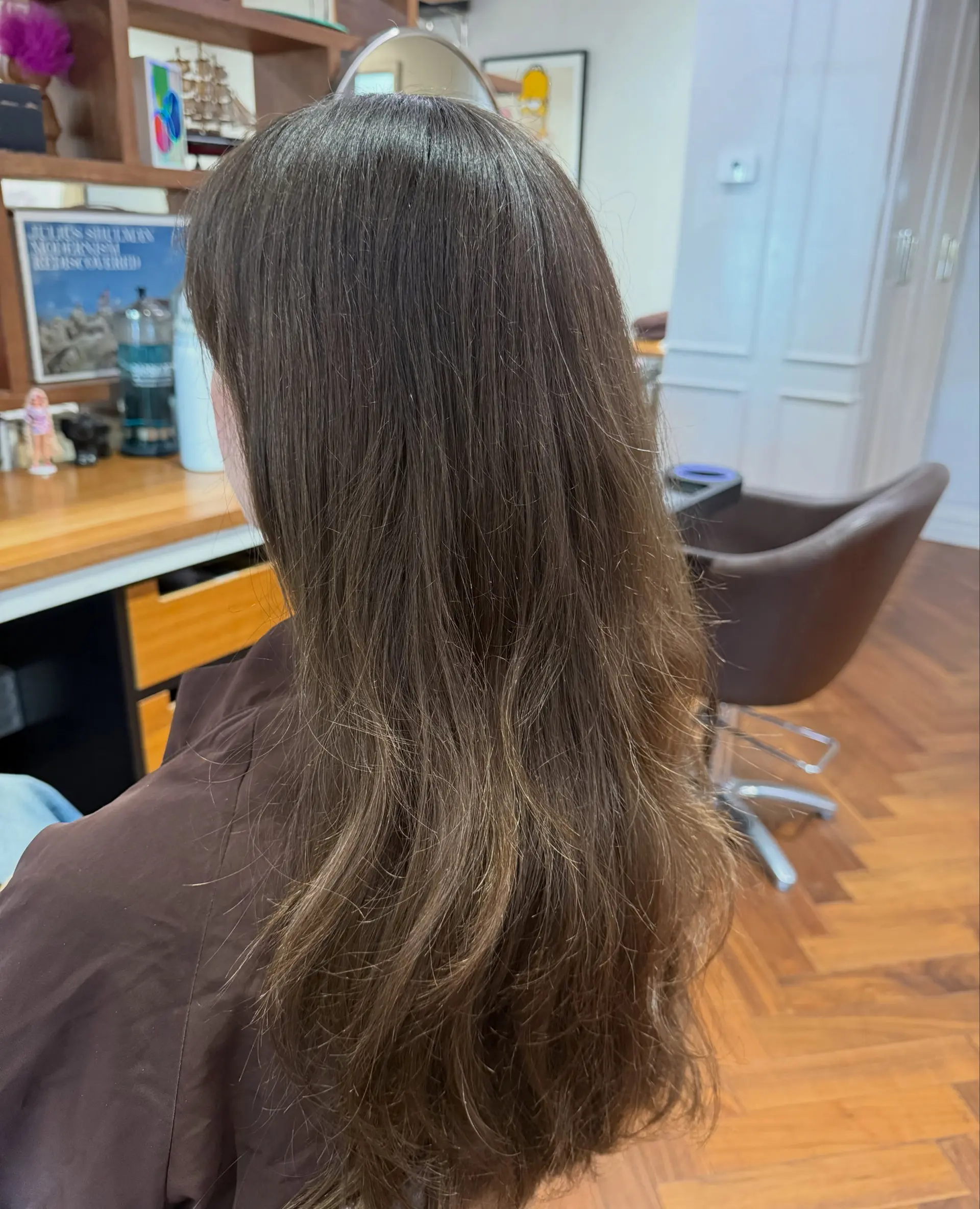 Long brunette hair featuring soft, dimensional honey-brown balayage highlights with gentle natural waves at the ends. 1