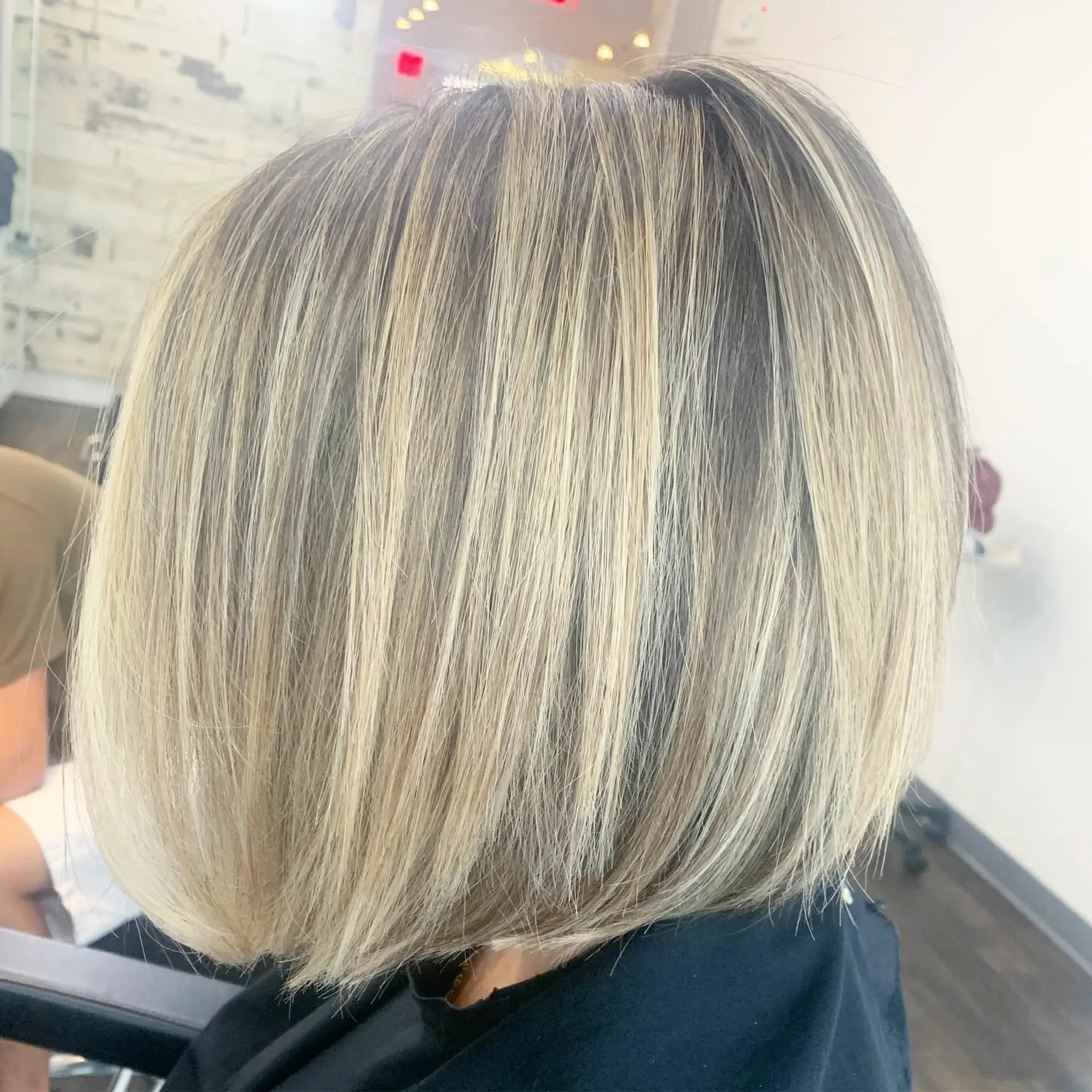A sleek, chin-grazing bob cut featuring finely blended blonde highlights and a smooth, straight finish. 1