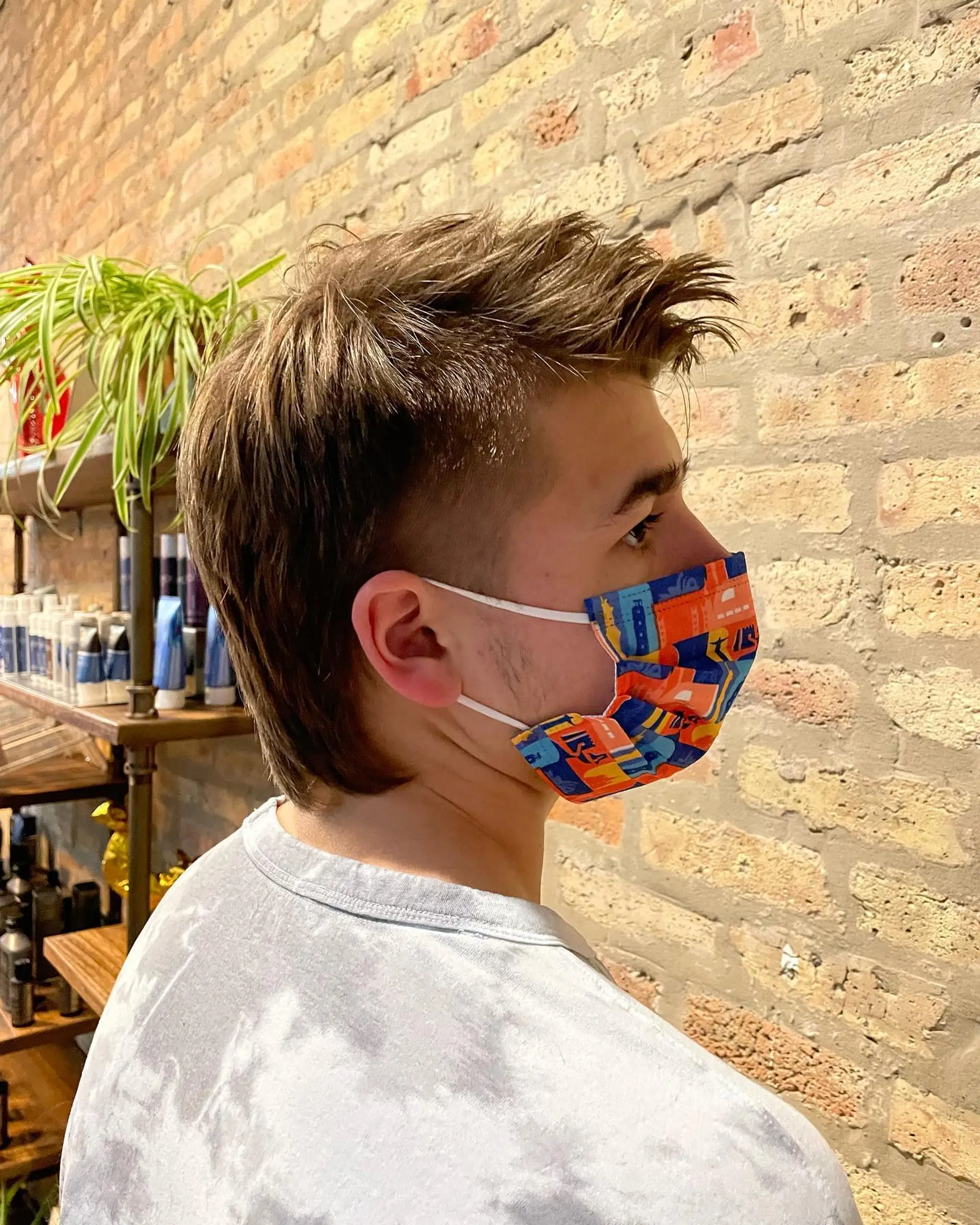 A modern textured mullet featuring clipped, tapered sides around the ears, a textured spiky top, and length extending down the nape. 1