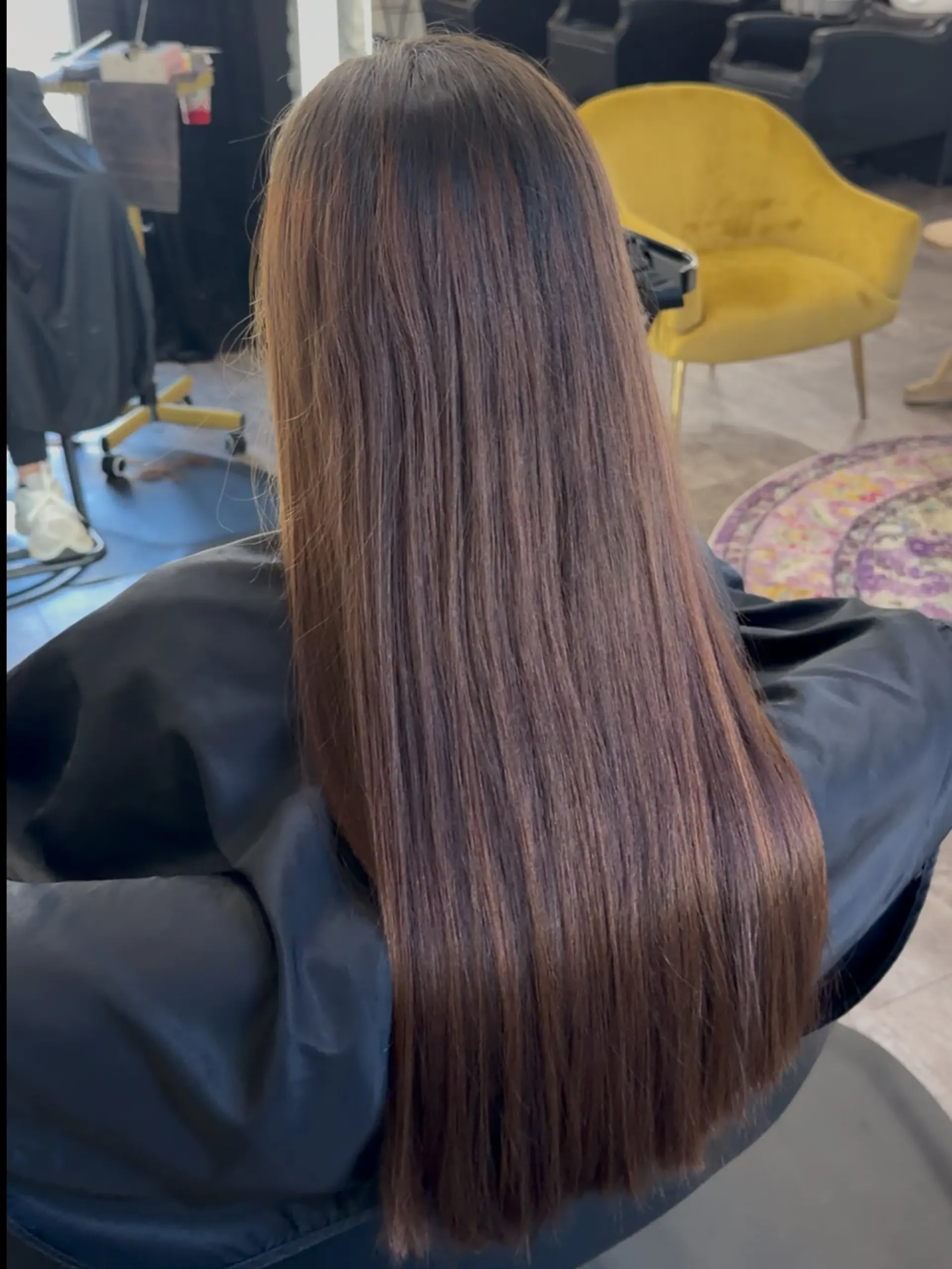 Extra-long, straight hair featuring soft dimensional brunette tones with subtle warm highlights. 1