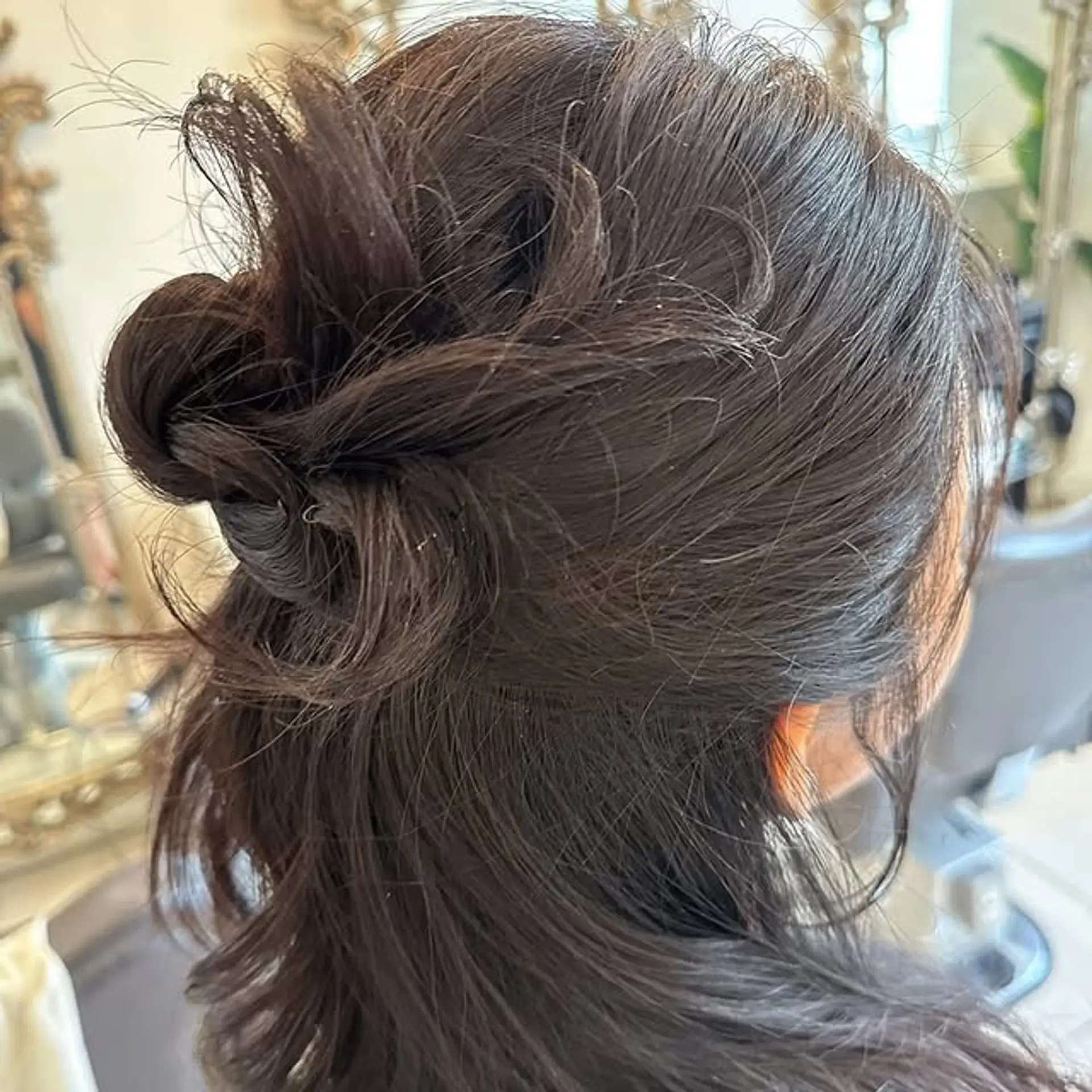 A simple and chic half-updo created by twisting sections of hair and securing them, leaving the rest of the hair flowing freely. 1