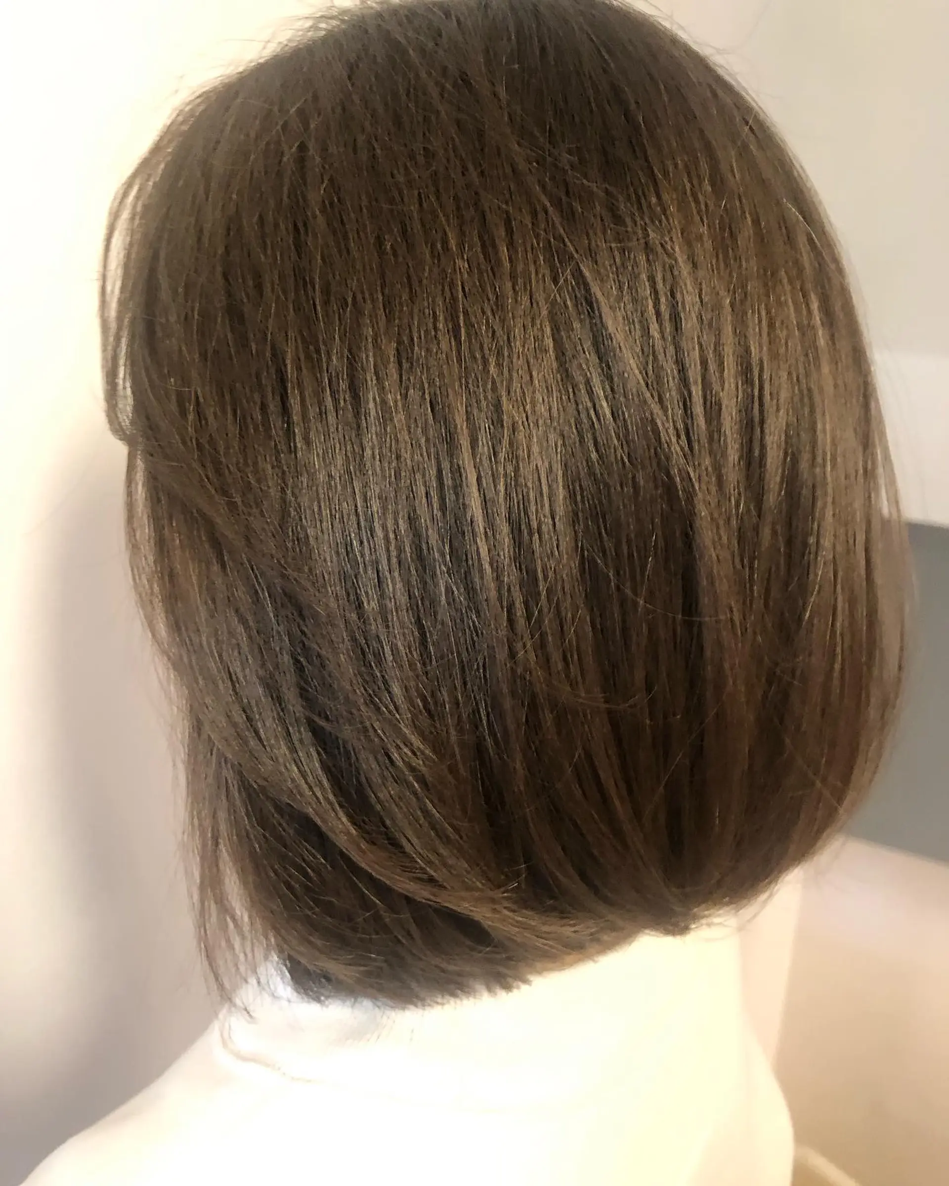 A classic short layered bob cut featuring soft internal layering and gentle inward beveling. 1