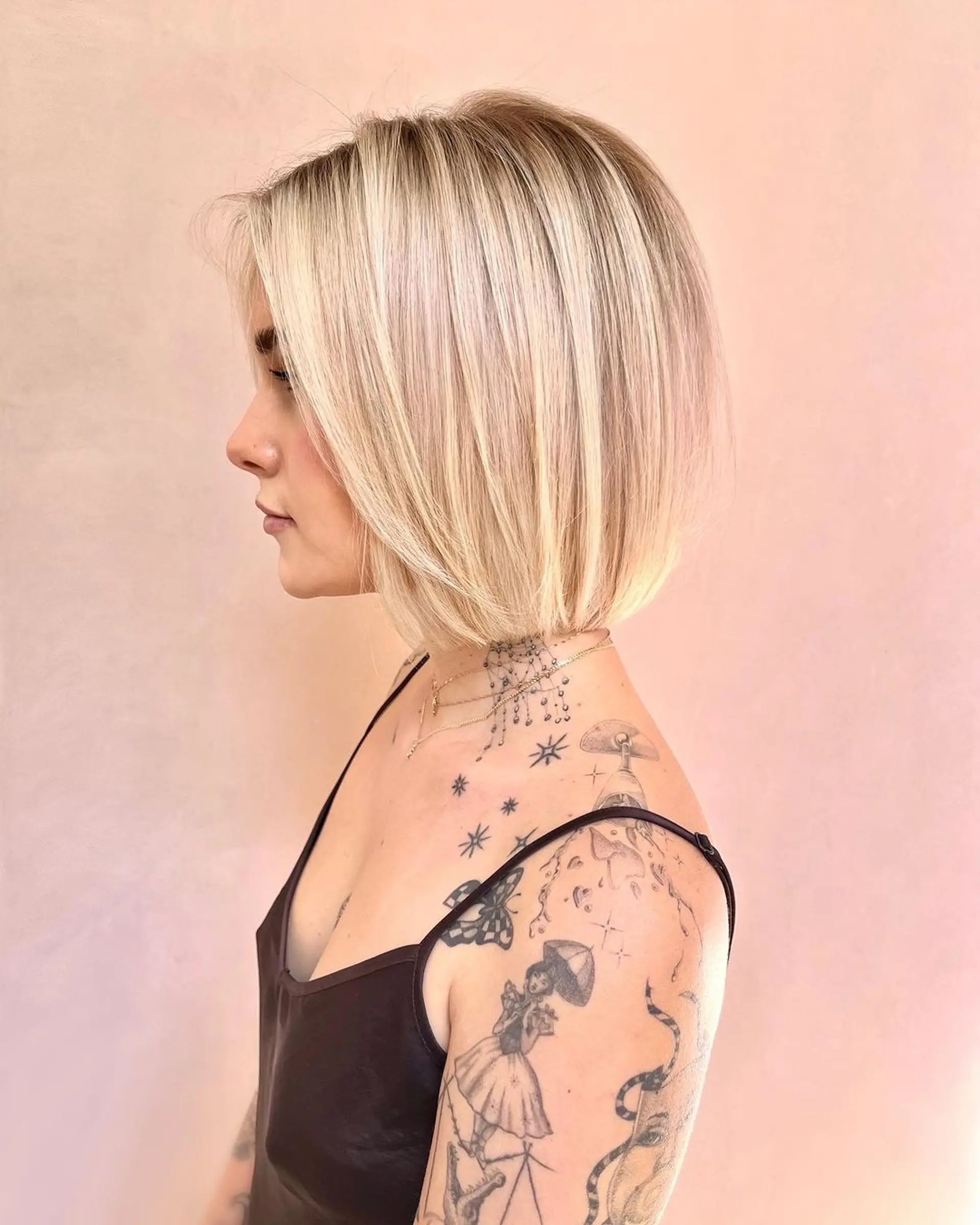 A sleek, straight blonde bob with multi-tonal shades of blonde, platinum, and ash, cut just below the chin with slight layering at the edges. 1