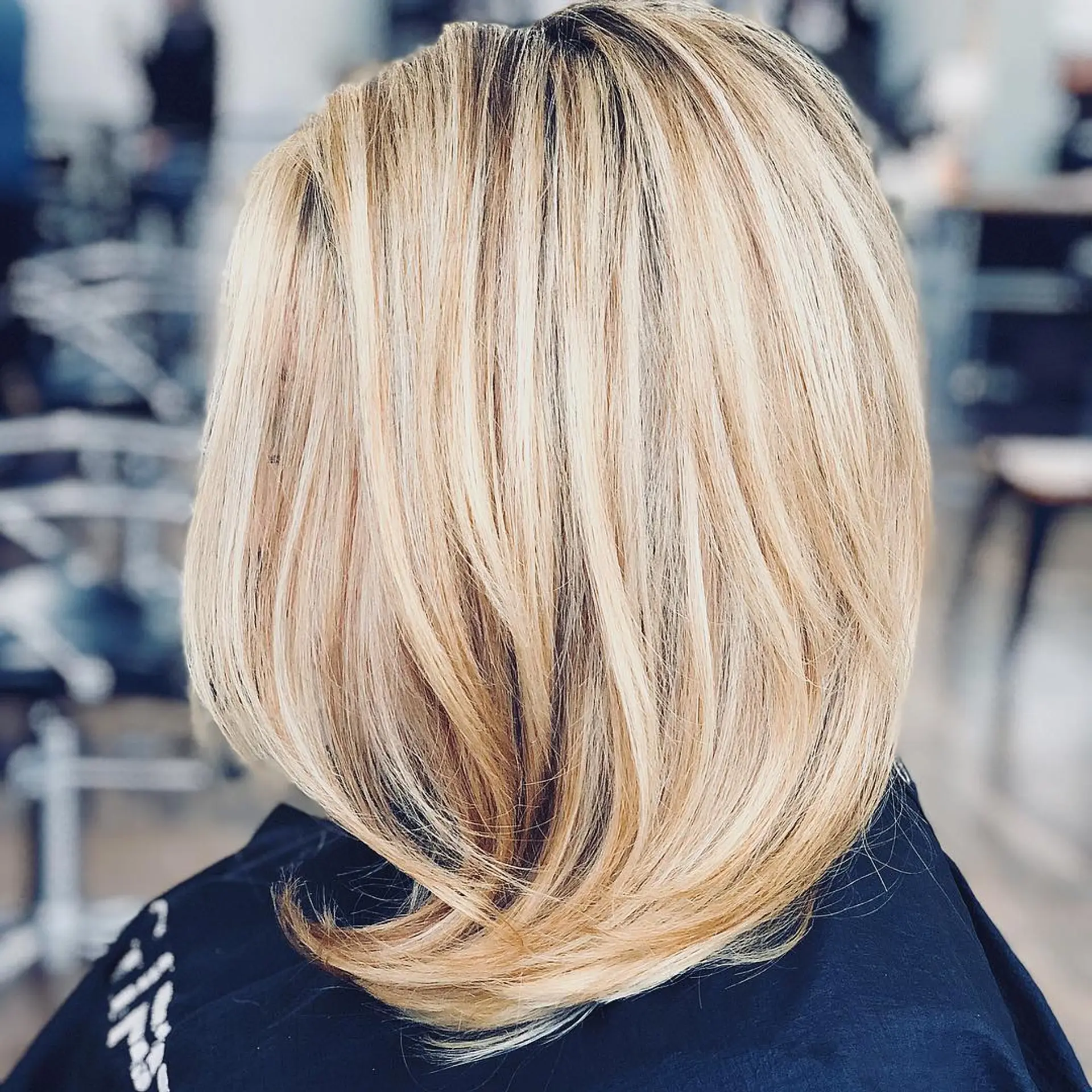 A textured medium-length lob featuring subtle layers and dimensional painted blonde highlights. 1