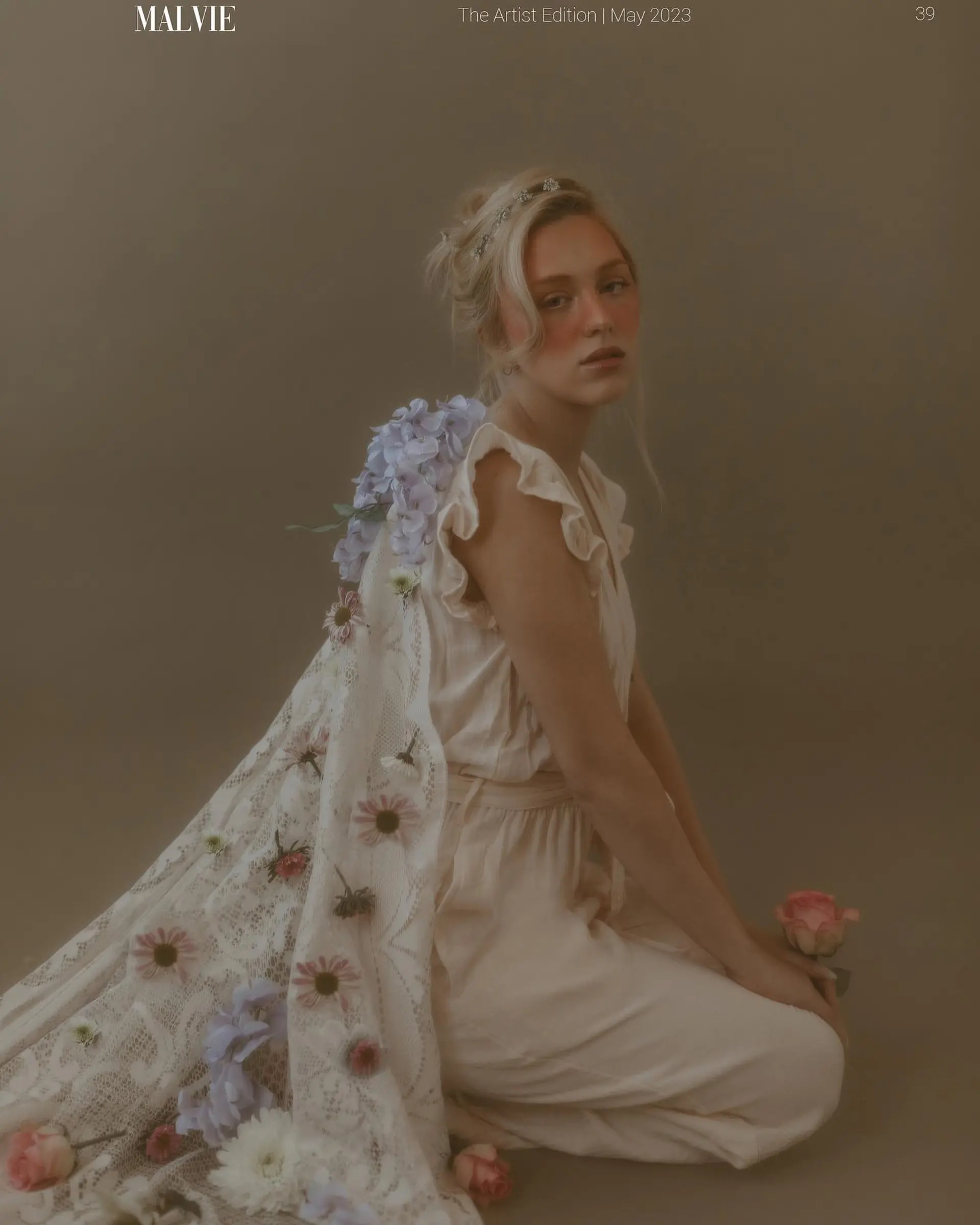A soft, romantic editorial updo styled with wispy face-framing tendrils and a subtle decorative hairpiece. 1