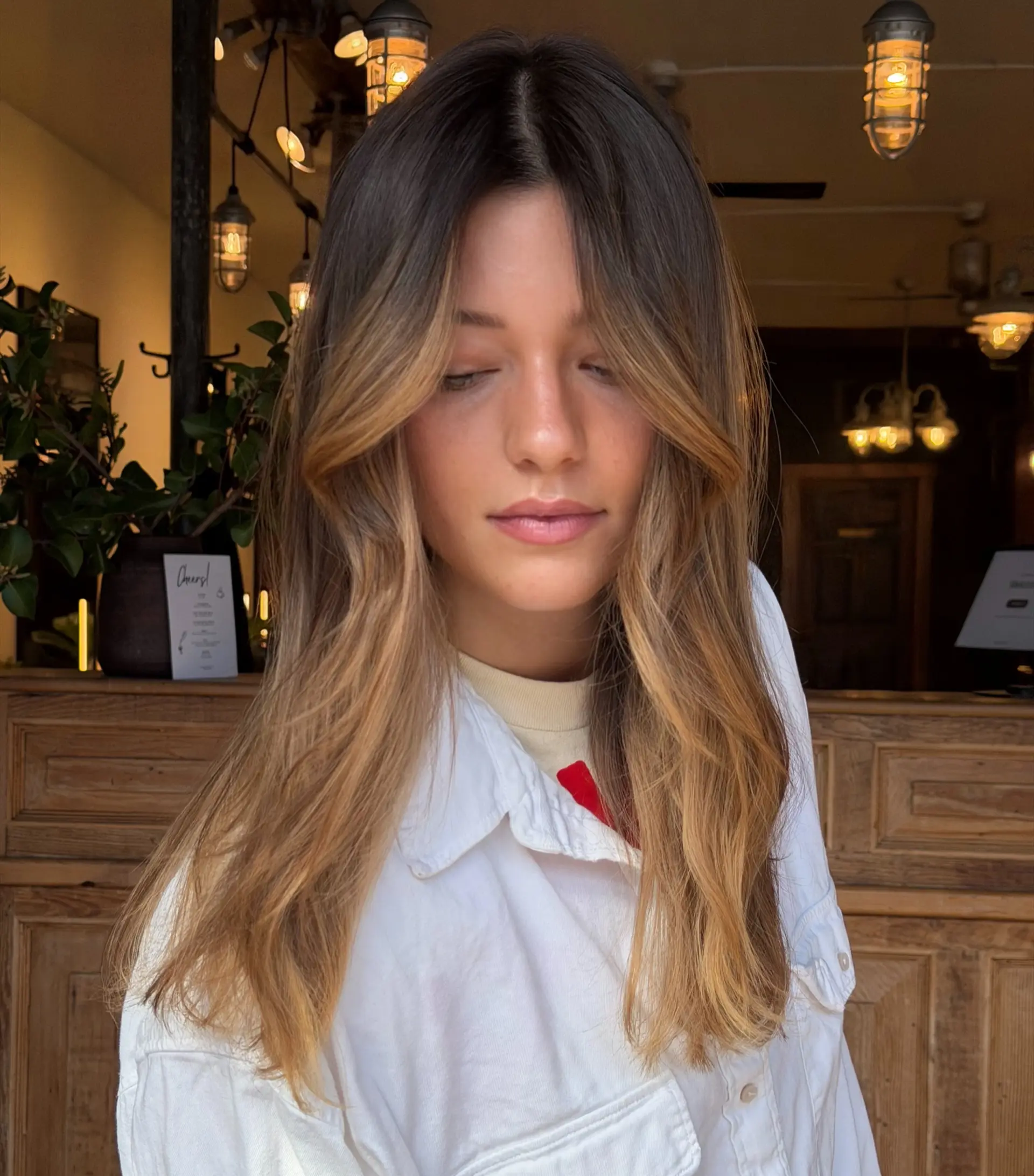 Long layered haircut featuring soft face-framing curtain bangs and gentle styling. 1