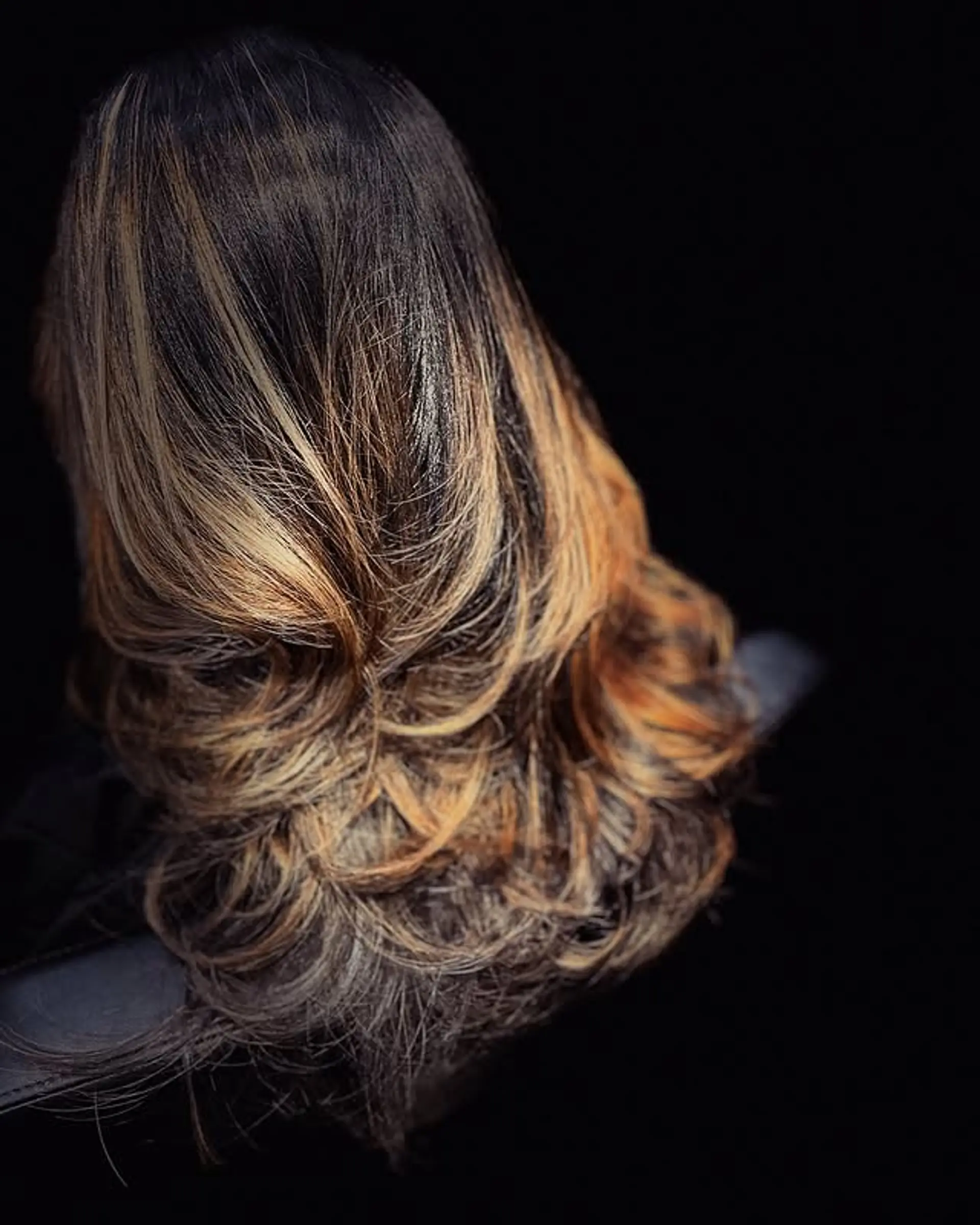 A wavy, medium-length hairstyle featuring caramel blonde highlights. 1