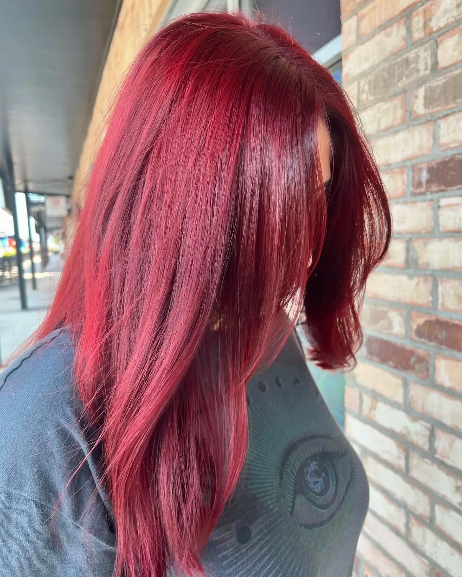 Vibrant crimson red long hair styled sleek and straight with gentle face-framing layers. 1