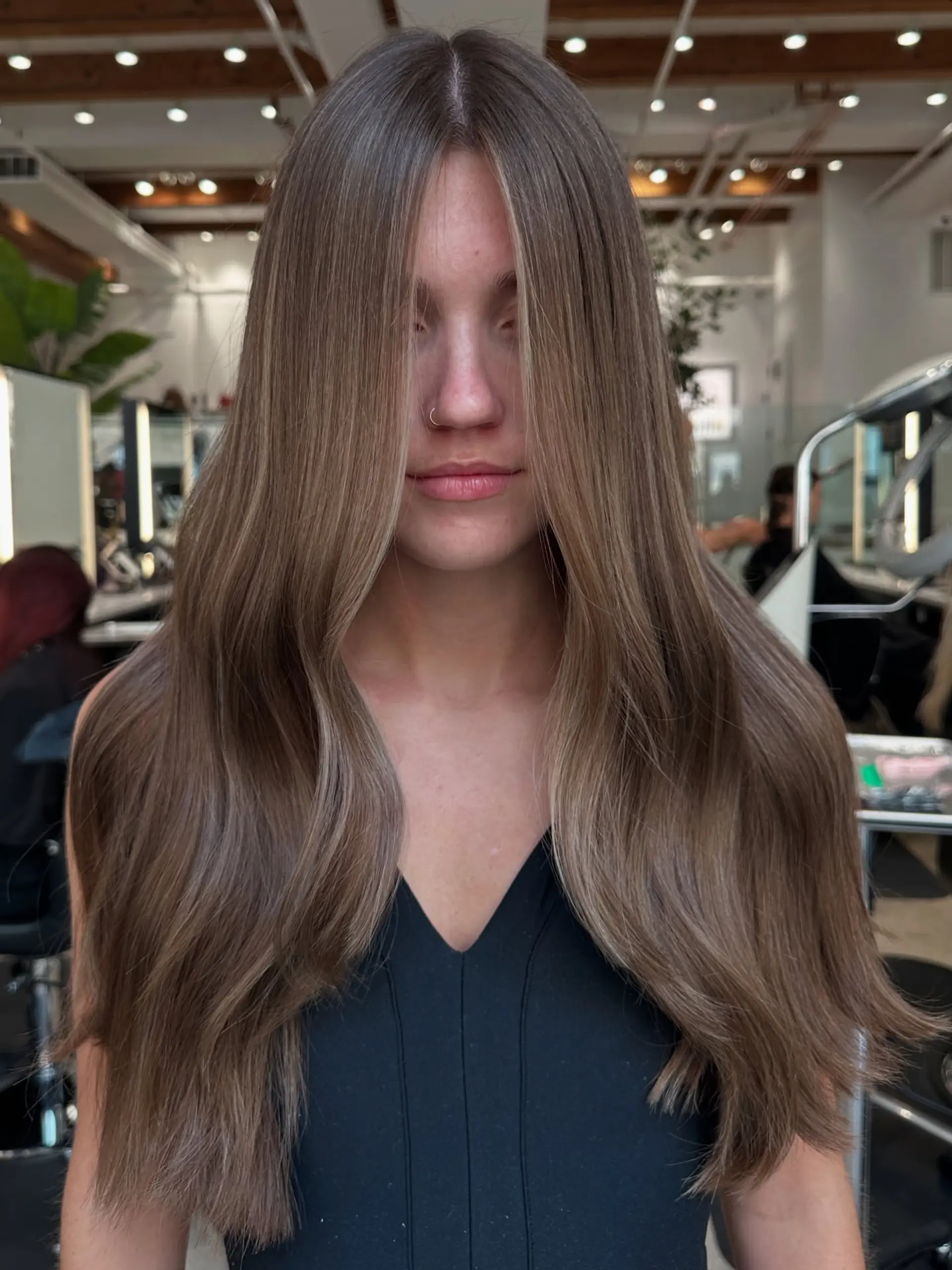 A long, bronzed hairstyle featuring subtle waves and bright face-framing highlights. 1
