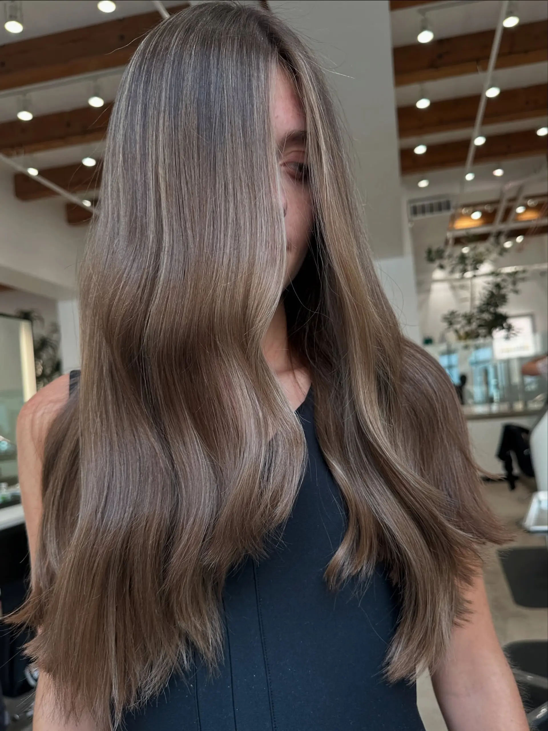 A long, bronzed hairstyle featuring subtle waves and bright face-framing highlights. 2