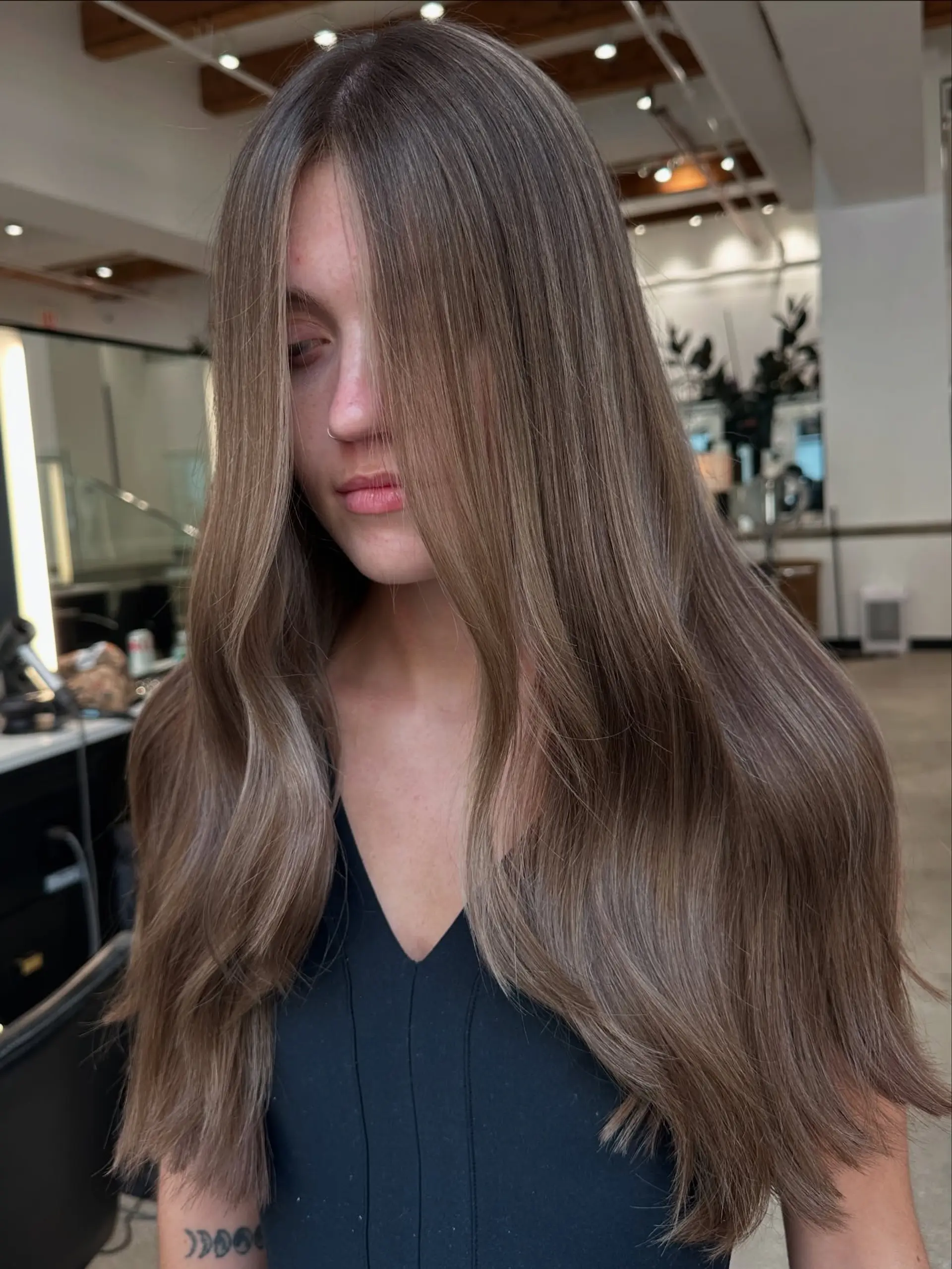 A long, bronzed hairstyle featuring subtle waves and bright face-framing highlights. 3