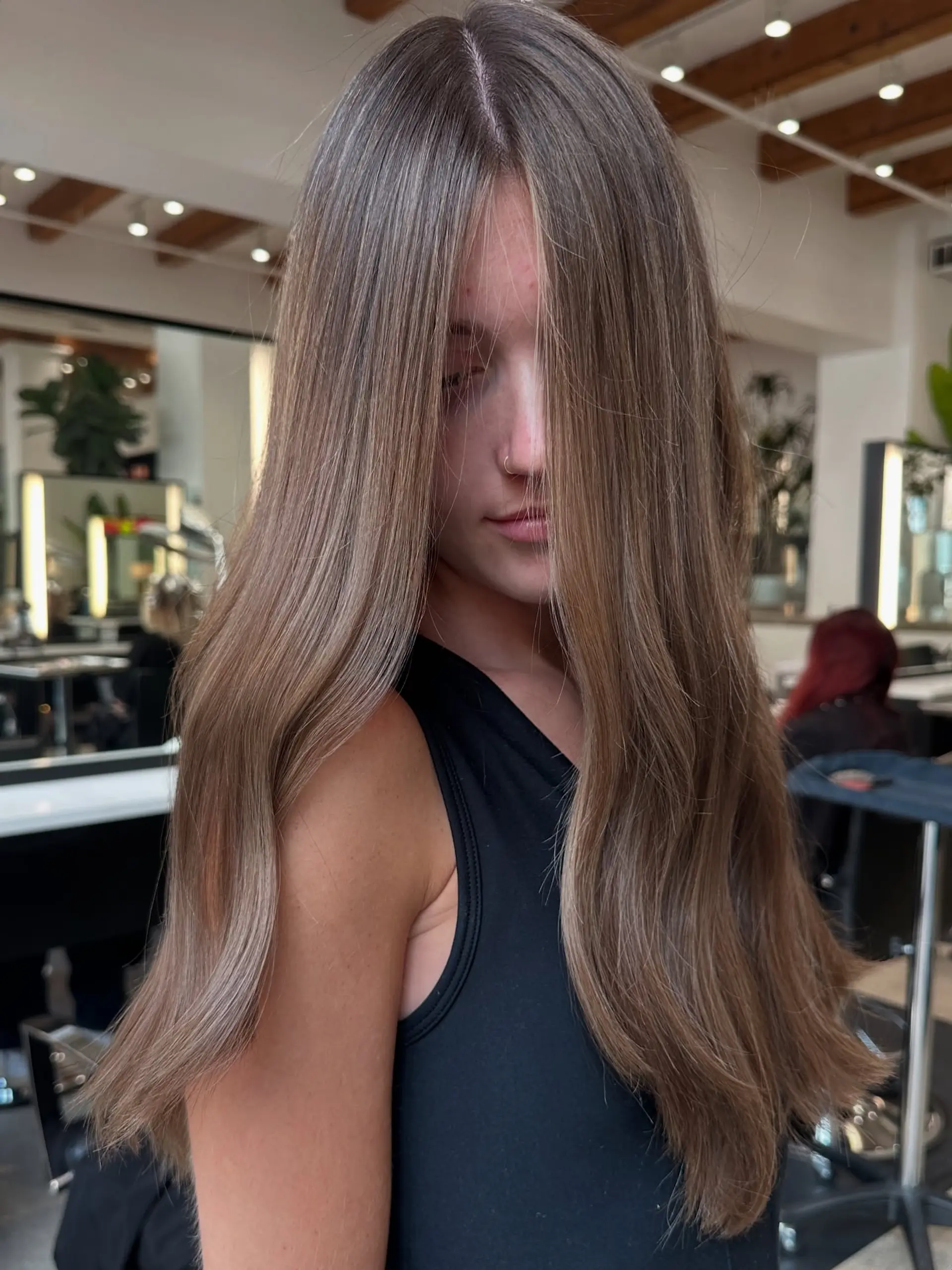 A long, bronzed hairstyle featuring subtle waves and bright face-framing highlights. 4