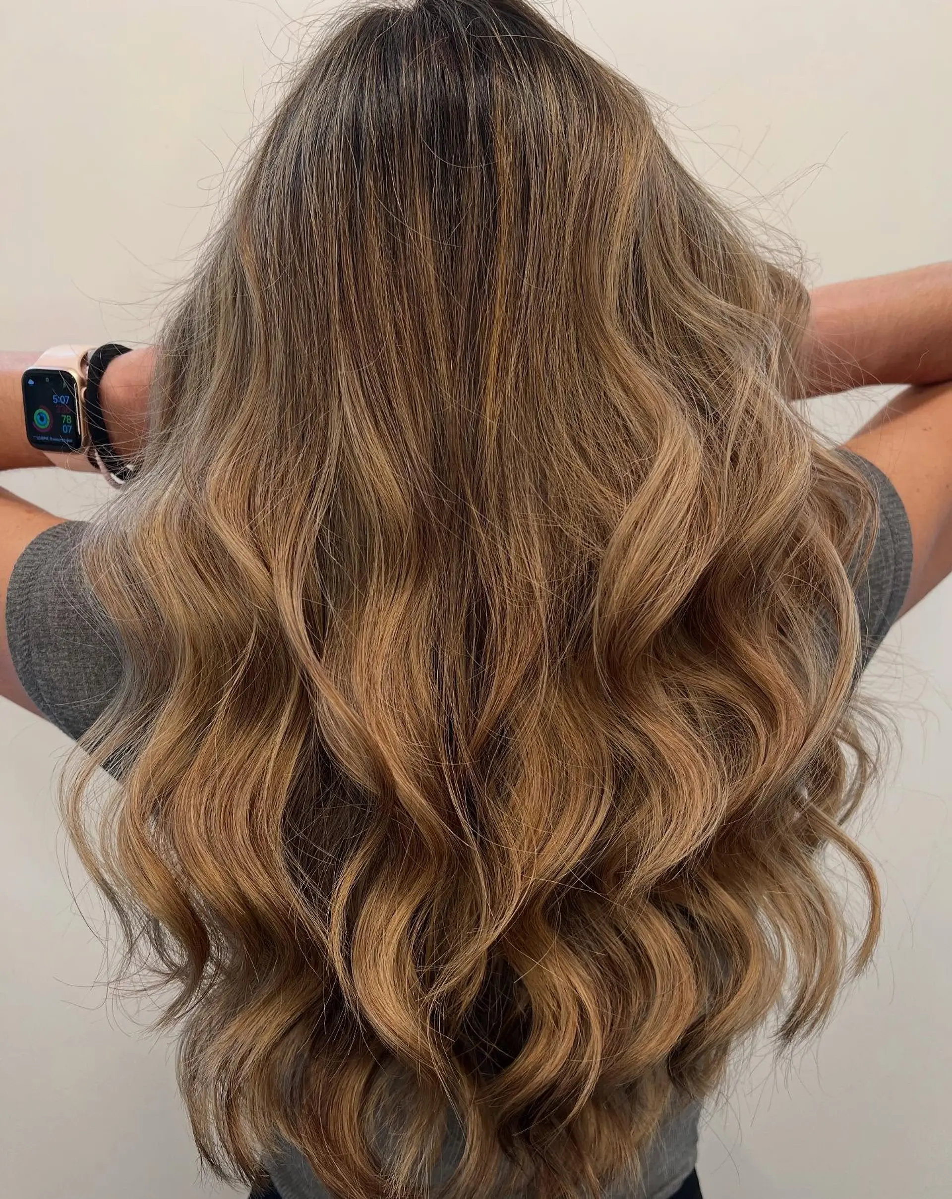 Long cascading waves featuring seamless sun-kissed honey and caramel balayage over a natural light brown base. 1
