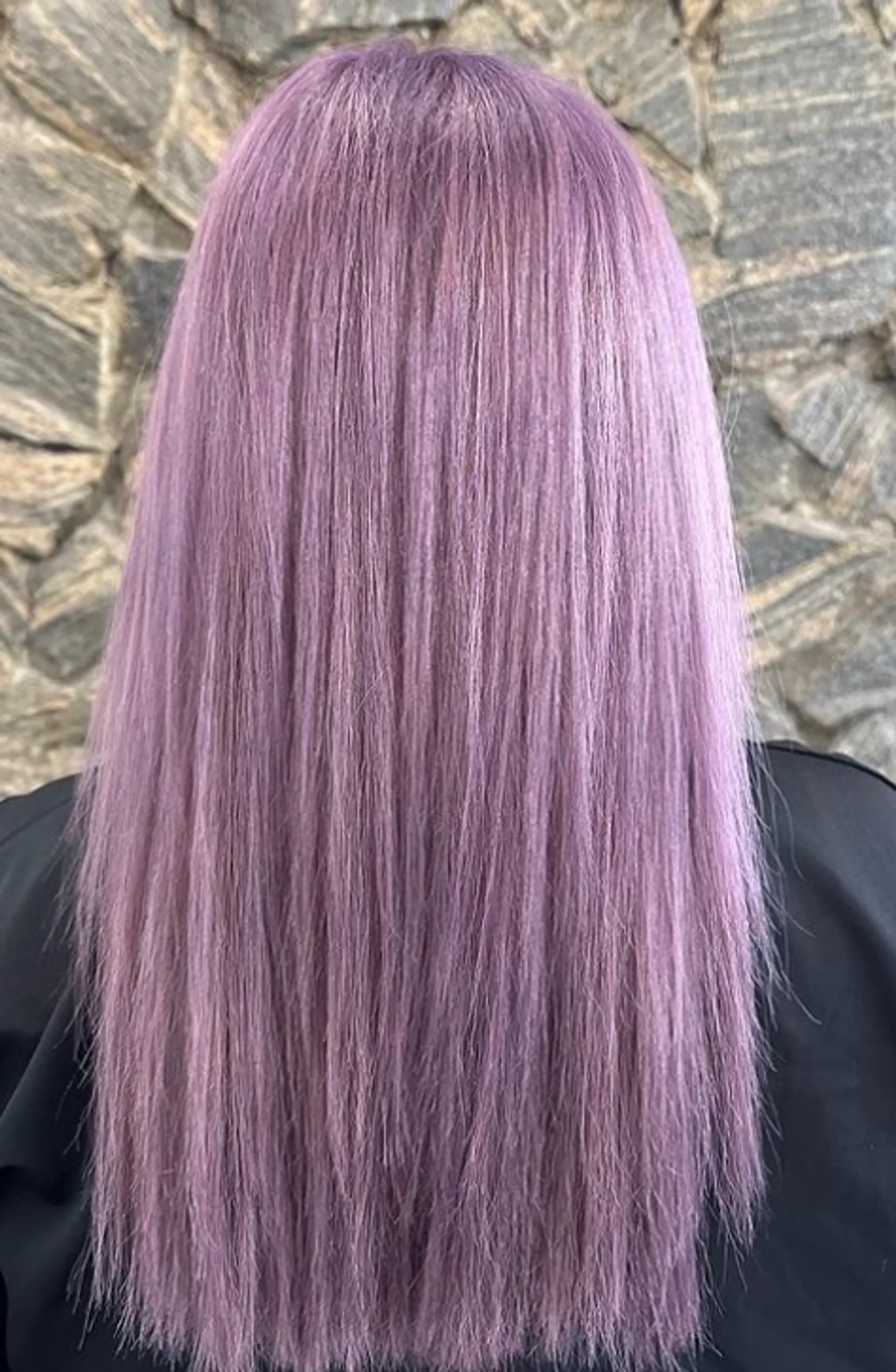 Long, sleek straight hair dyed a vibrant lavender, parted in the center with sections tucked behind the ears. 2