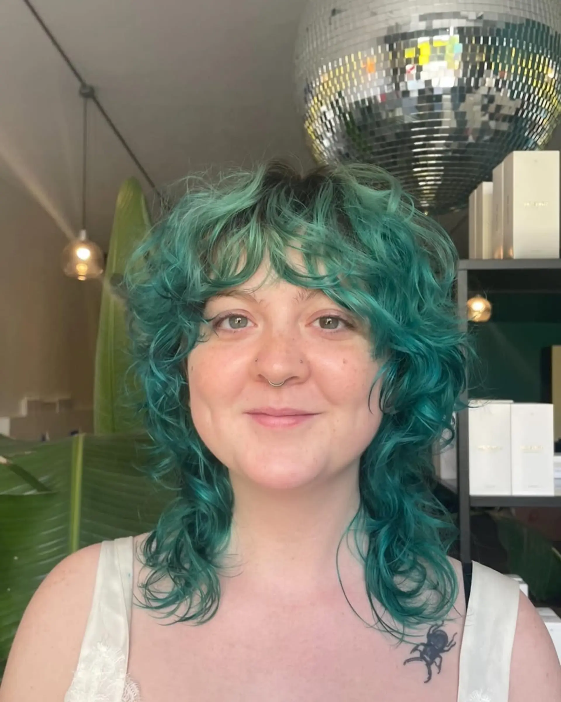 Medium-length, wavy teal hairstyle with shaggy layers and fringe bangs, creating a textured, voluminous look. 1