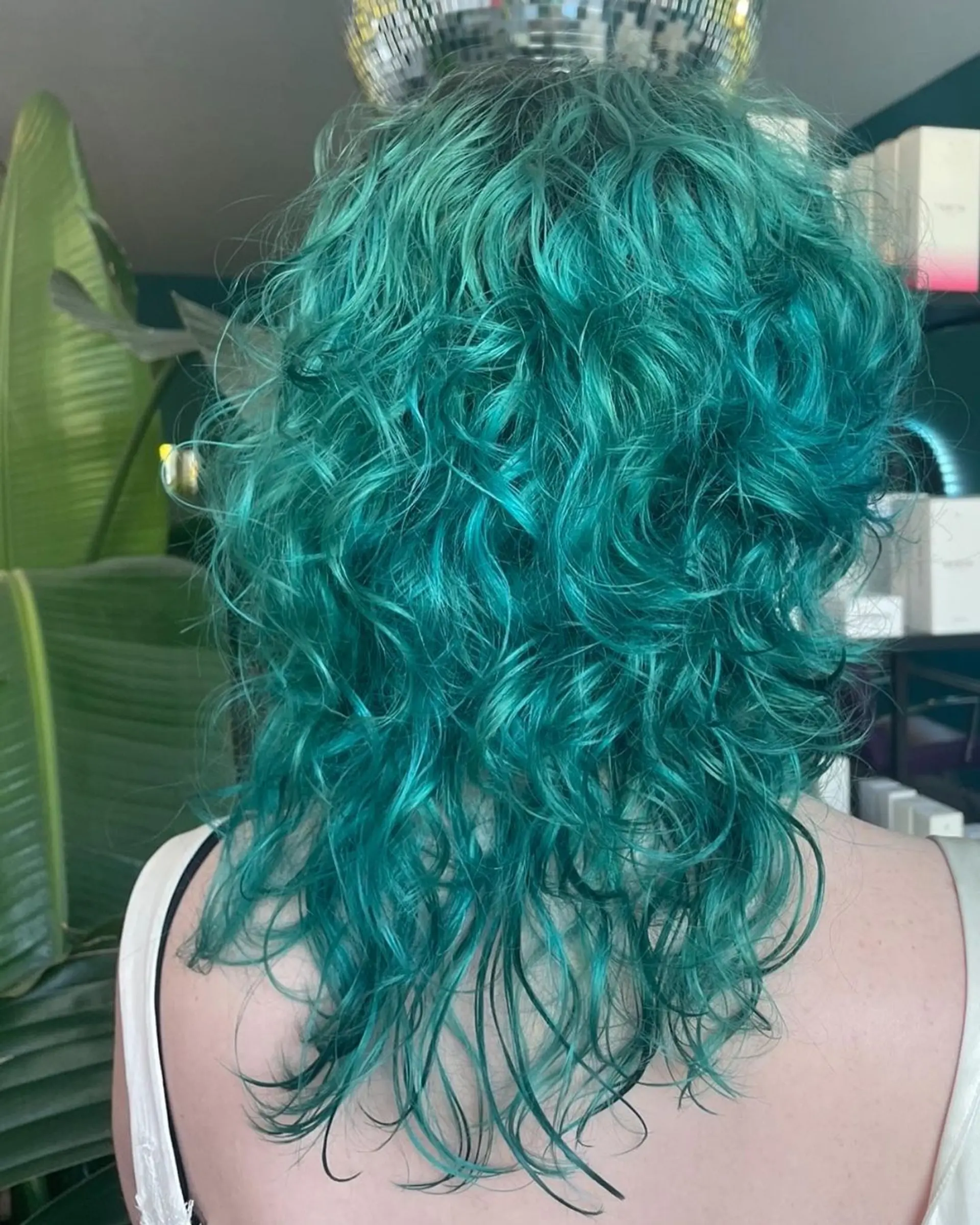 Medium-length, wavy teal hairstyle with shaggy layers and fringe bangs, creating a textured, voluminous look. 2