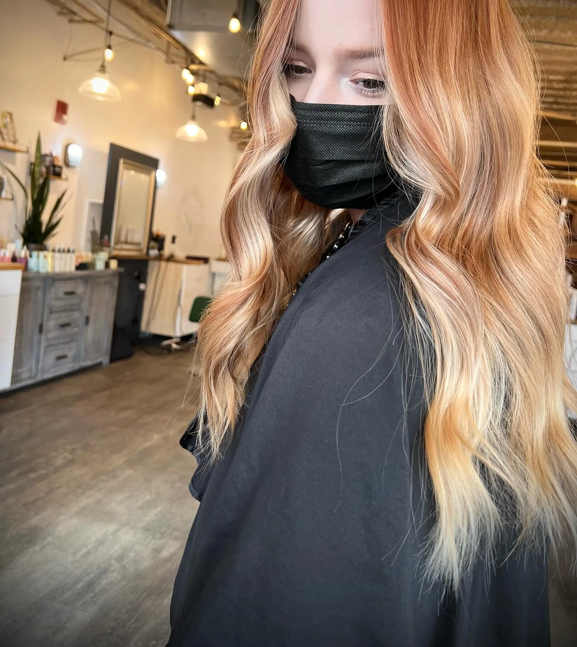 Long strawberry blonde hair styled into soft, flowing loose waves with bright face-framing money piece highlights. 1