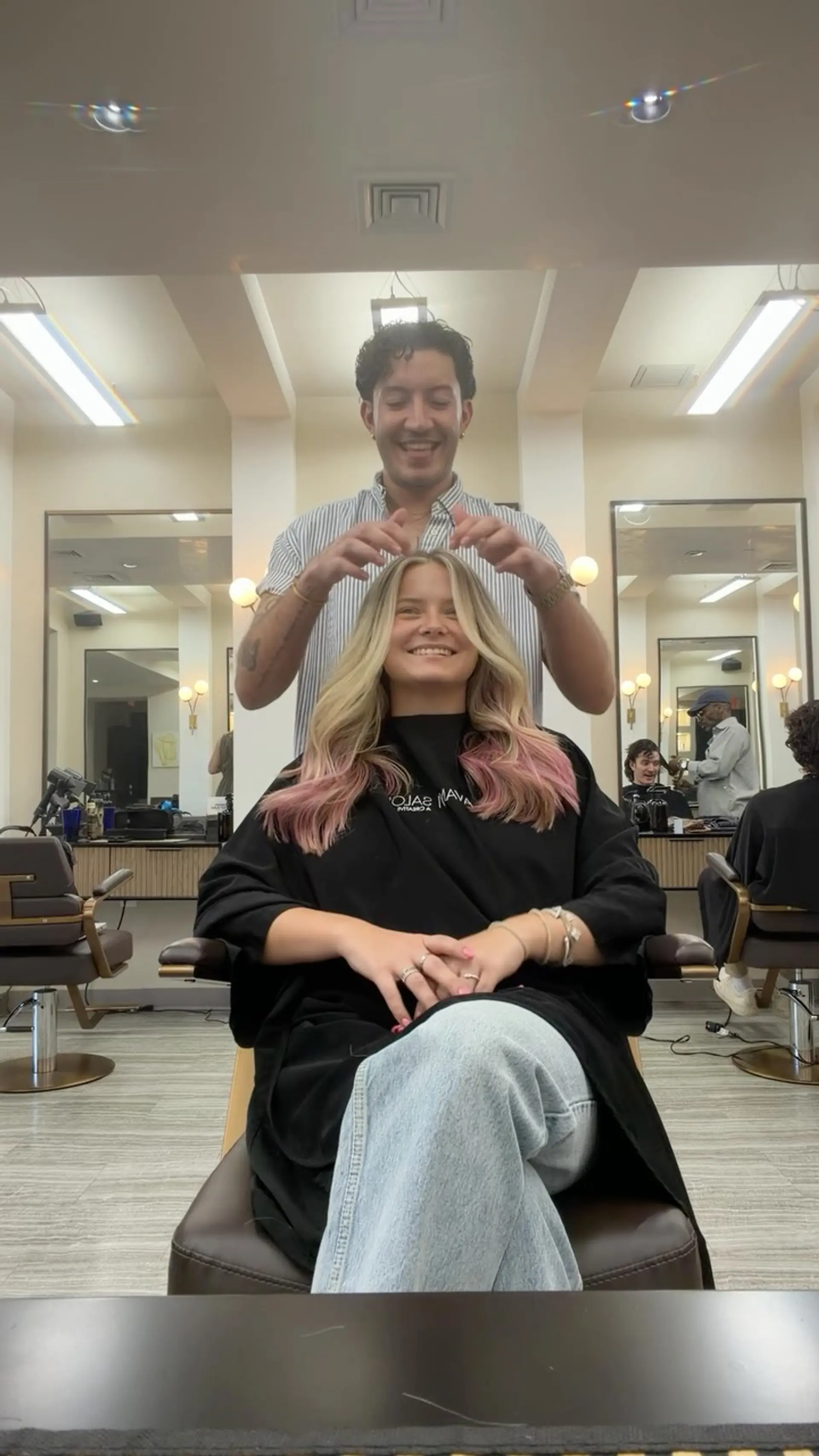 Long blonde hair styled in soft, bouncy waves featuring pastel pink dipped ends and a middle part. 1